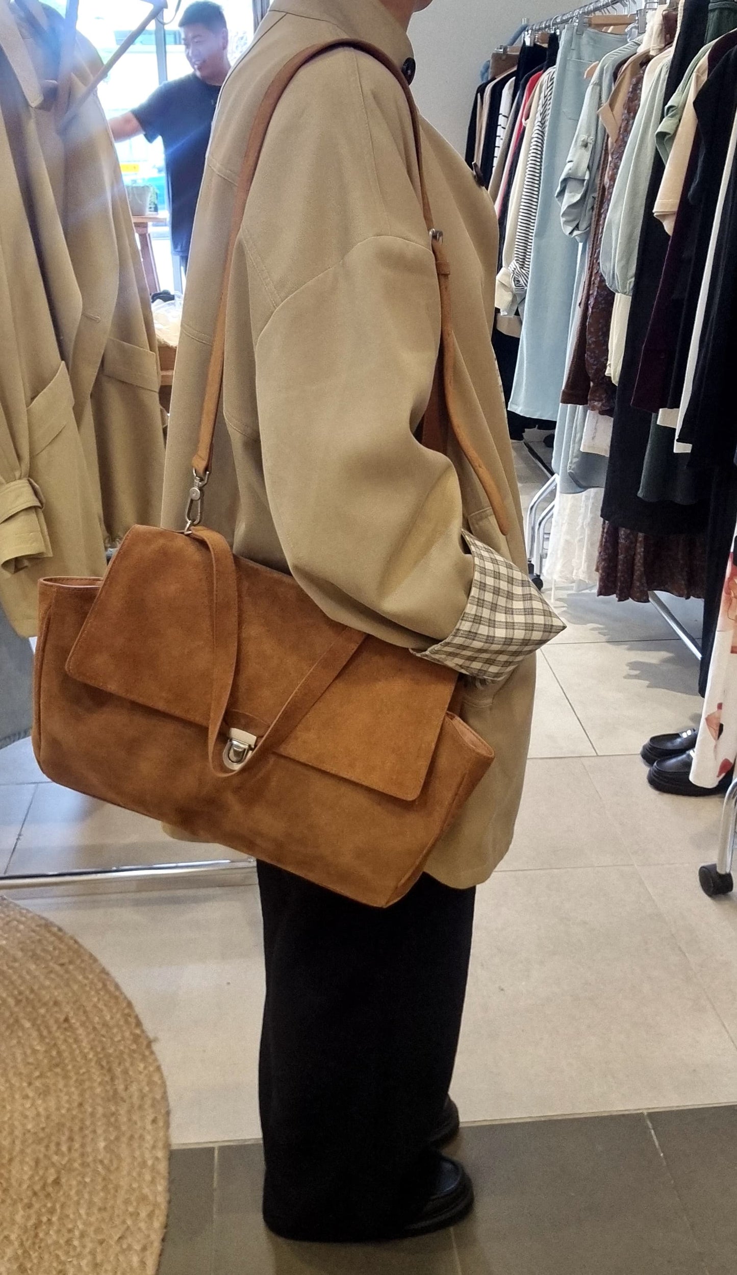 Side angle of Beige reversible trench coat styled with black pants