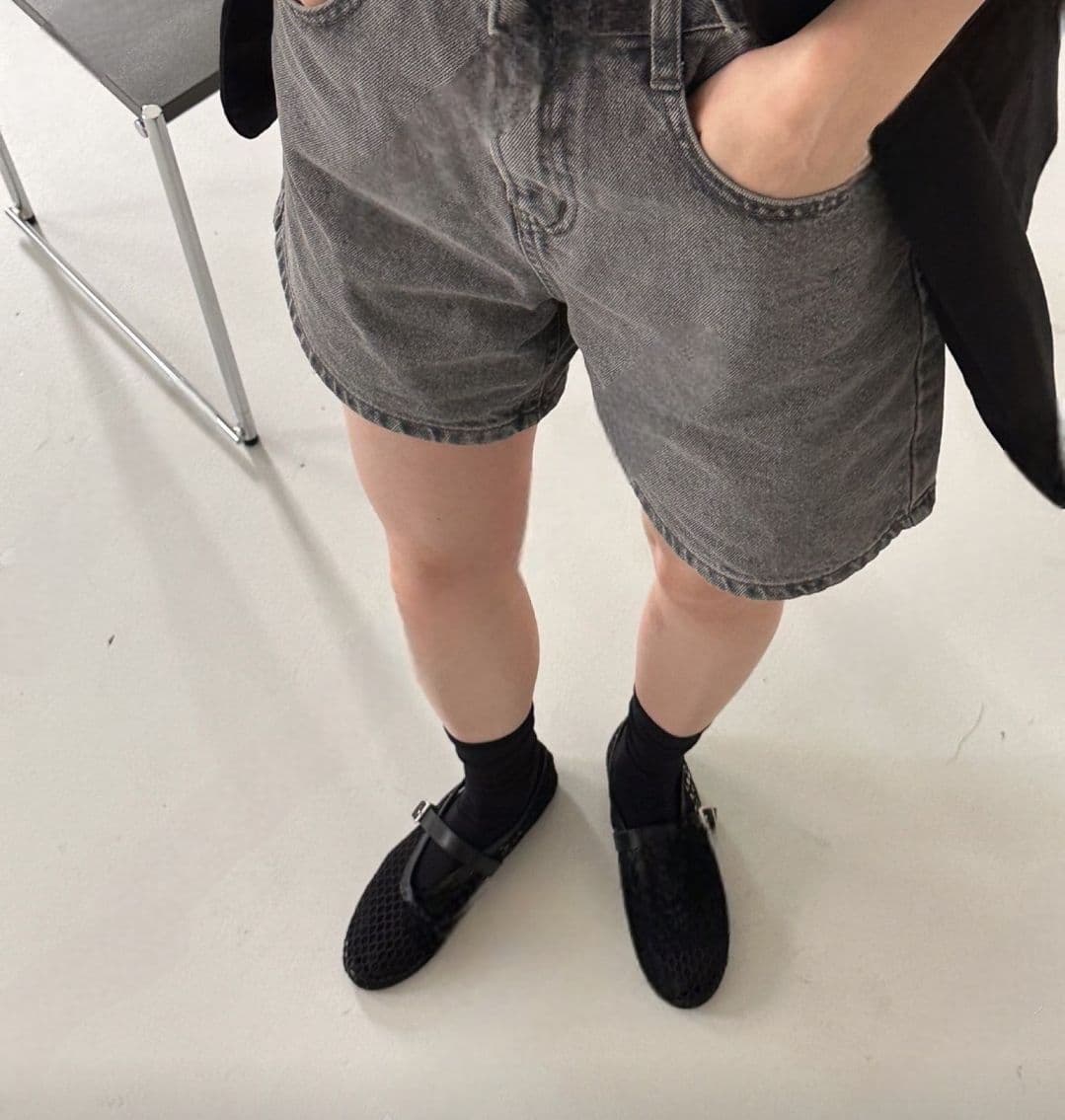 Black mesh Mary Jane flats worn with black socks, front view