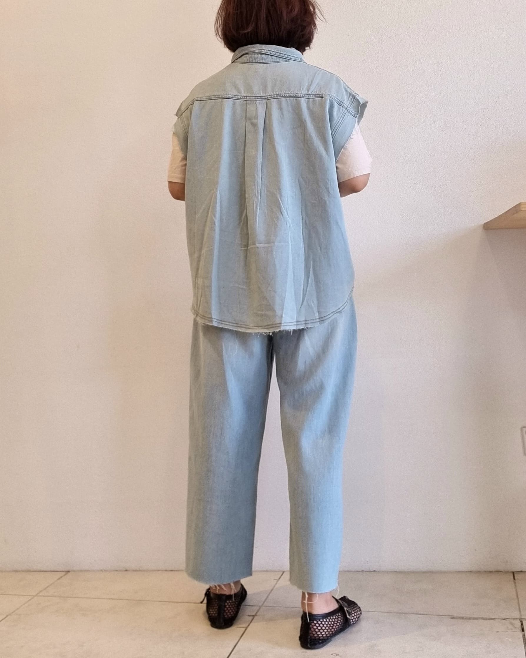 Light denim cotton vest, back view showing unbalanced hem.