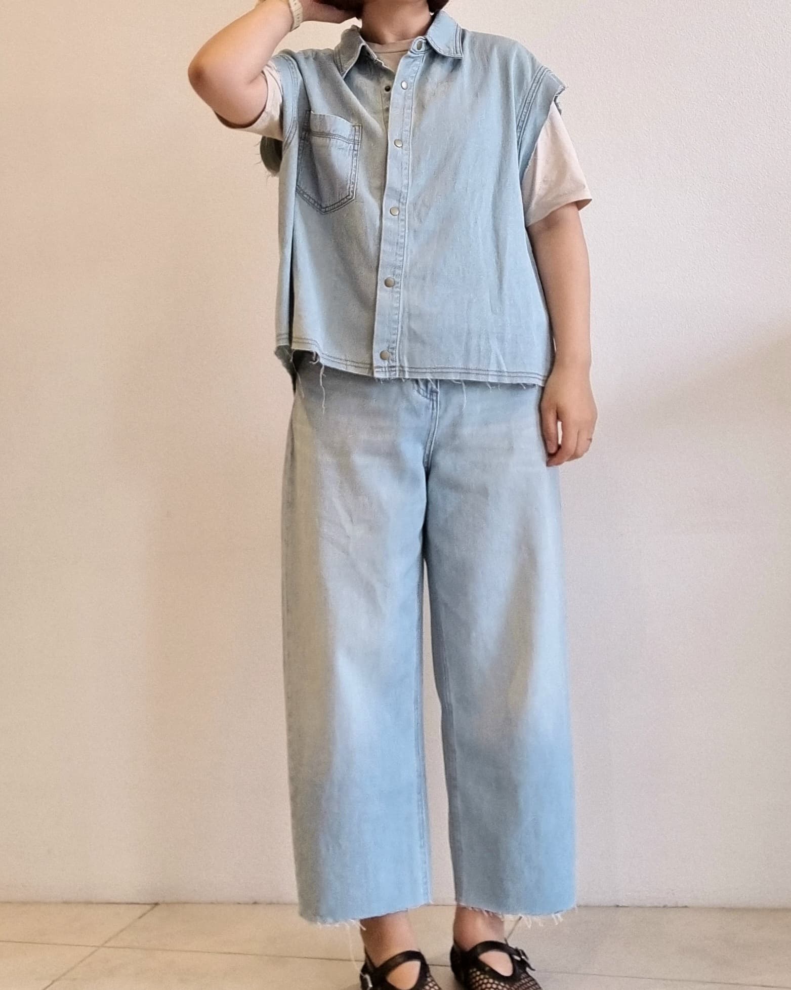 Light denim cotton vest, full body front view with relaxed wide-leg jeans.