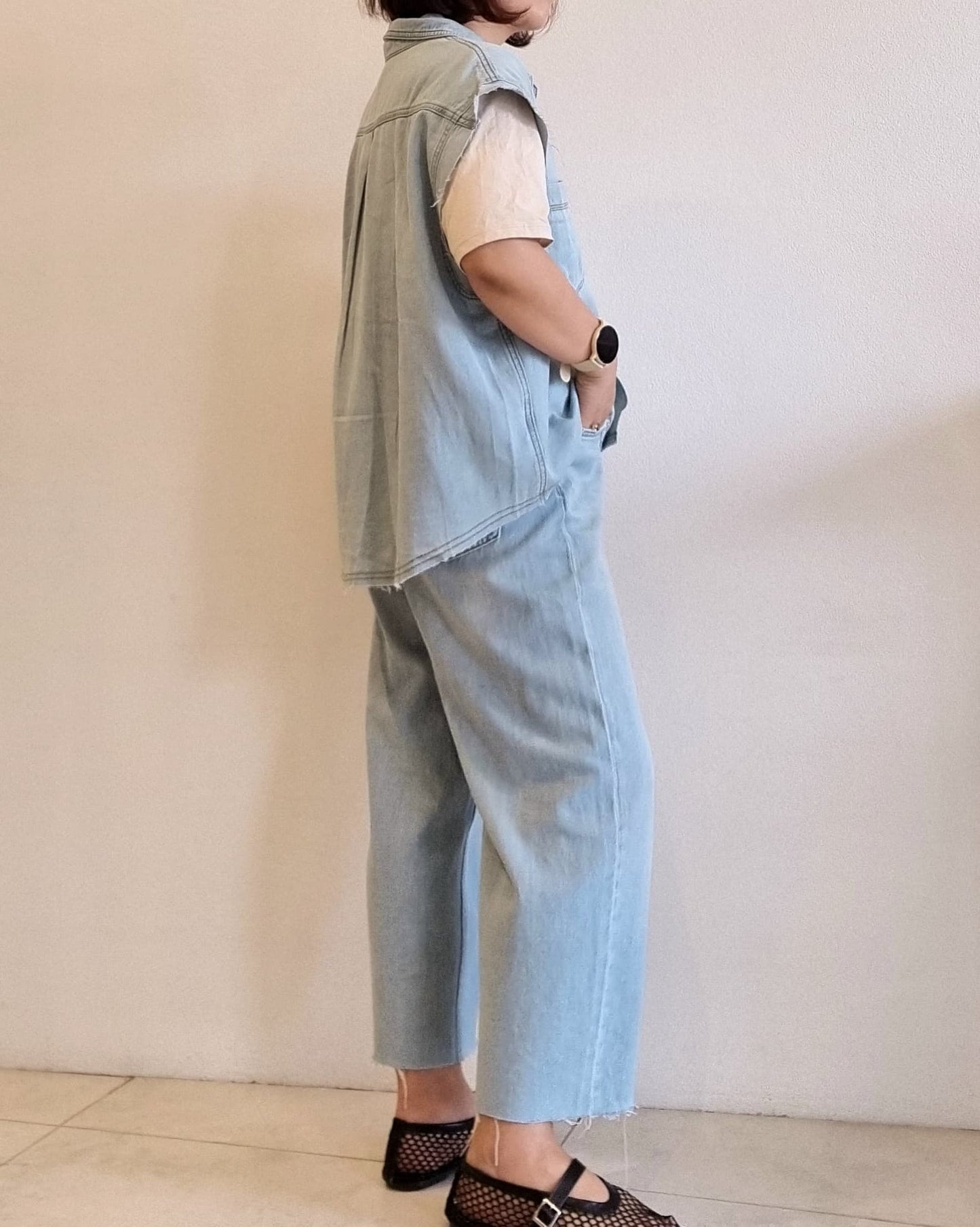 Light denim cotton vest, side view showing relaxed fit and armhole.