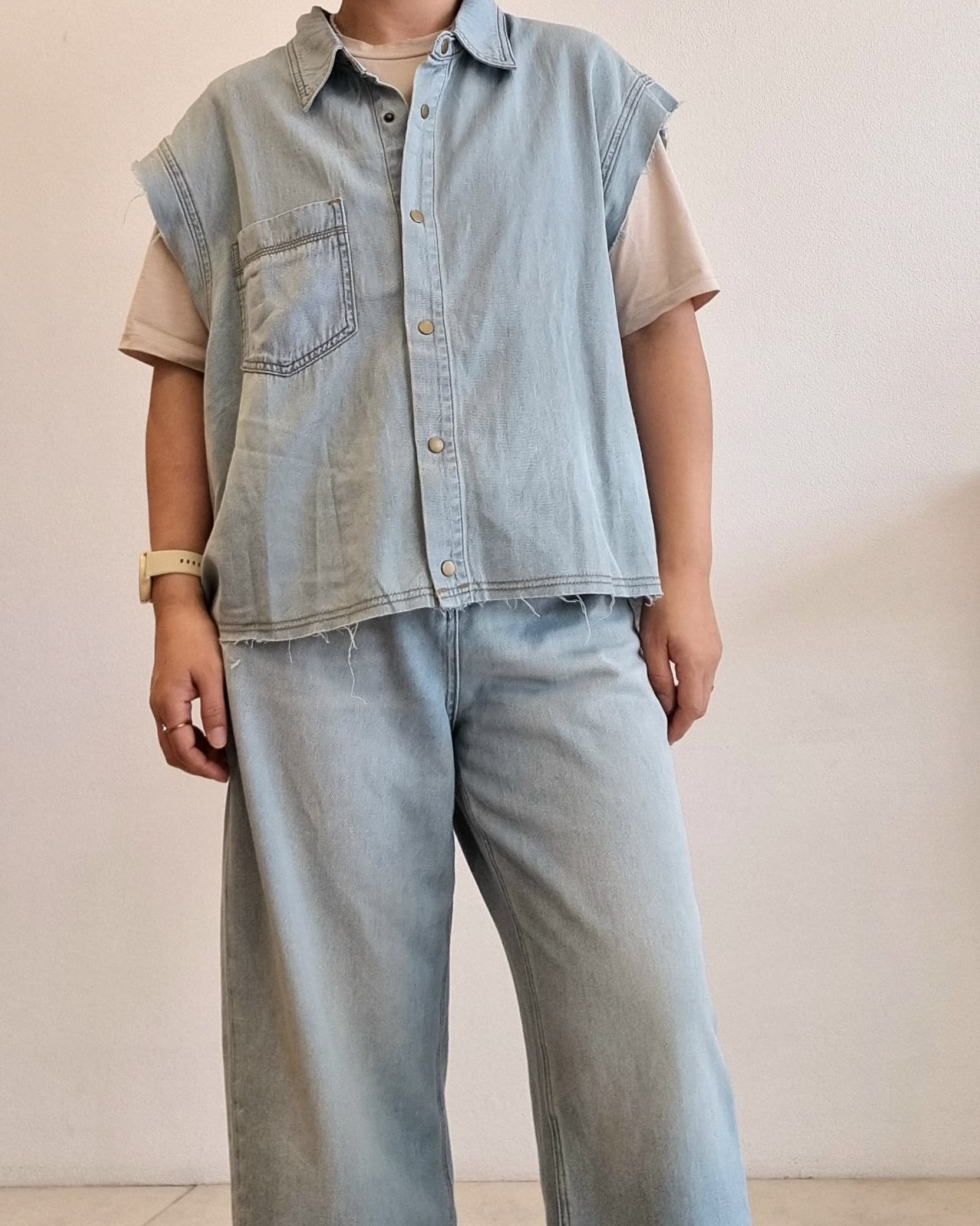 Light denim cotton vest on model, slightly angled front view.