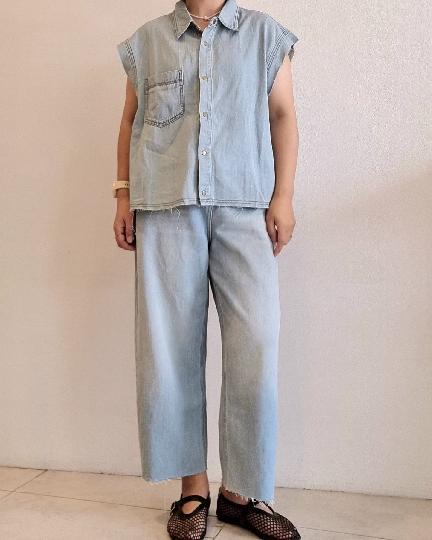 Light denim cotton vest on model, front view, snap button design.