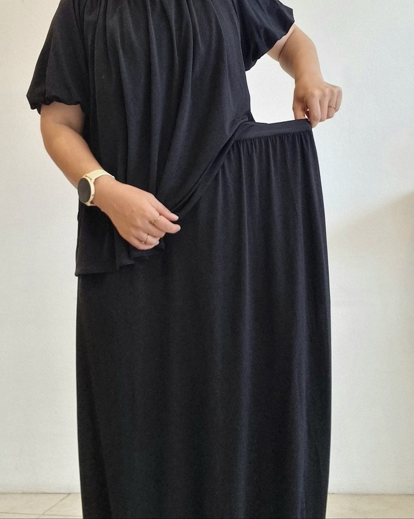 Black two-piece skirt showing stretchable waistband and soft drape fabric.