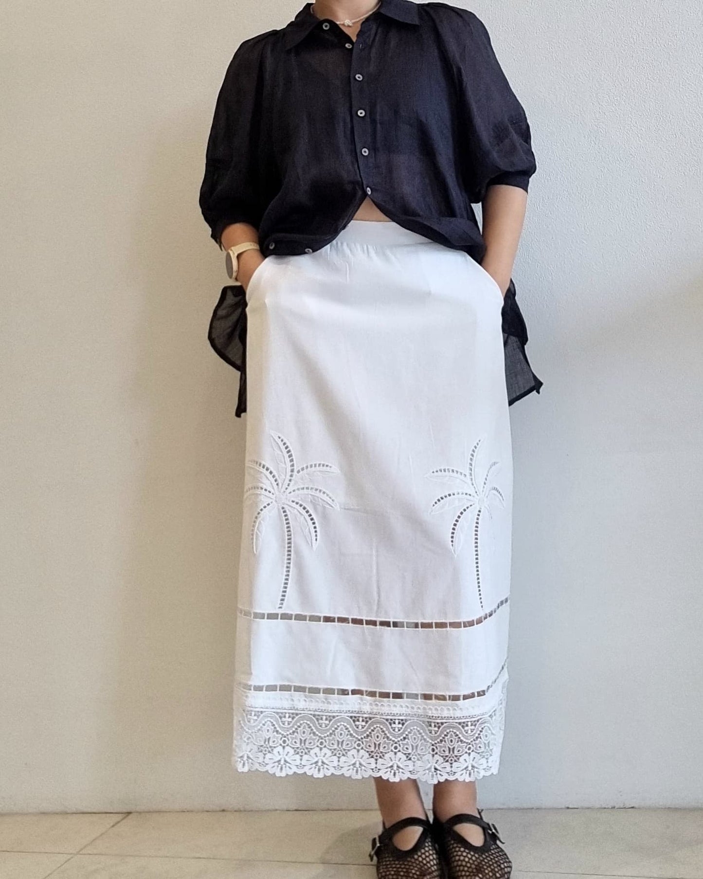 Full-length view of the white lace skirt styled with a black blouse.