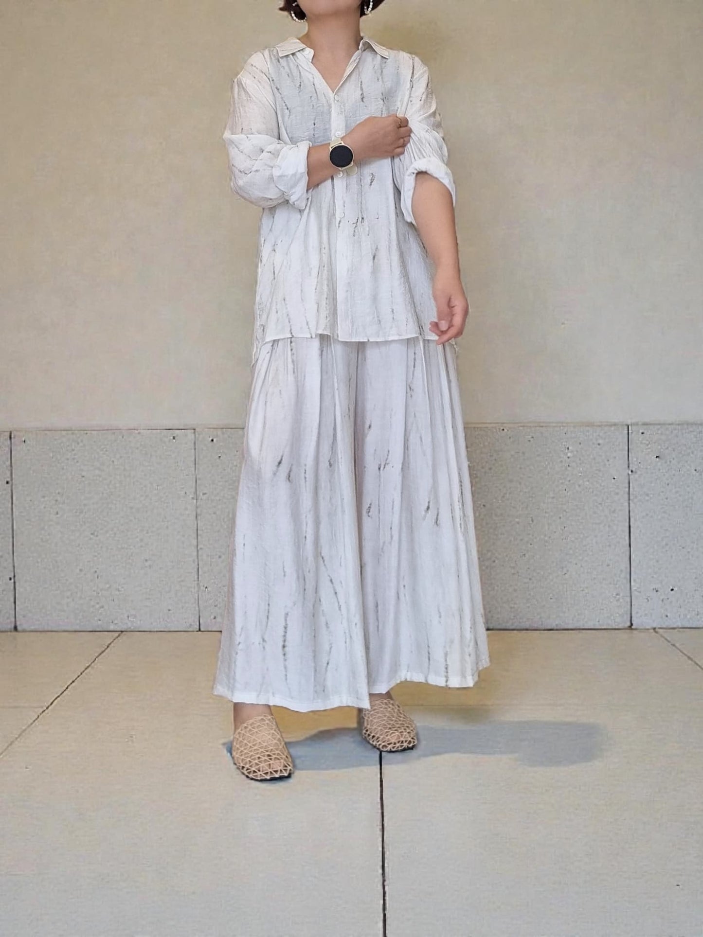 “Front view of model wearing the Oceanus wrinkle-free lightweight wide-leg pants with natural marble pattern, paired with matching shirt against a neutral wall – Nova Lux”