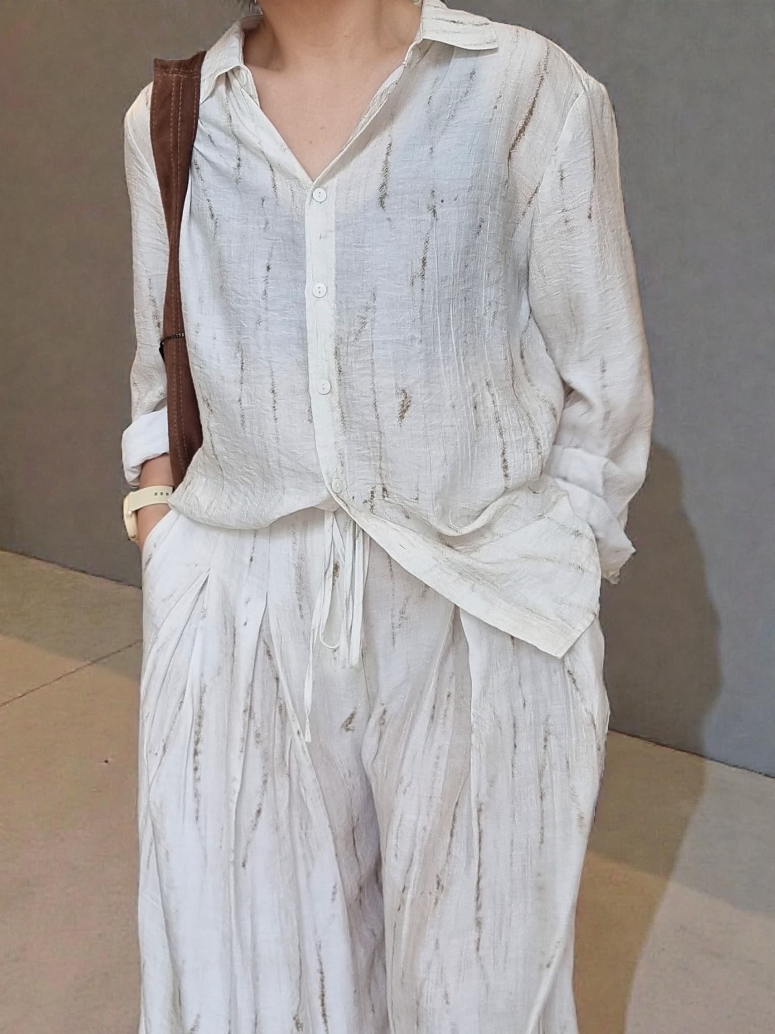 “Oceanus wrinkle-free lightweight shirt and pants set worn by model, natural marble pattern outfit against a neutral wall background – Nova Lux”