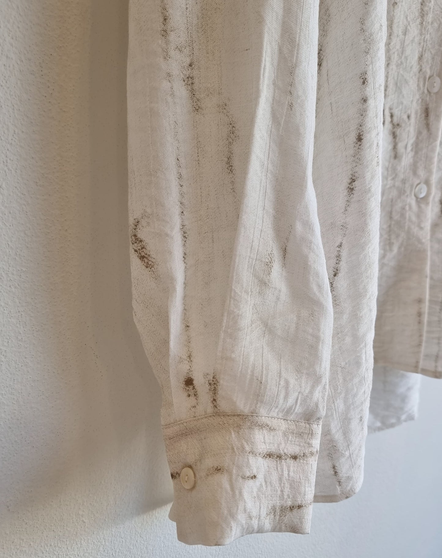 “Close-up of Oceanus wrinkle-free lightweight shirt showing marble-pattern fabric and cuff detail against a neutral wall – Nova Lux product detail”