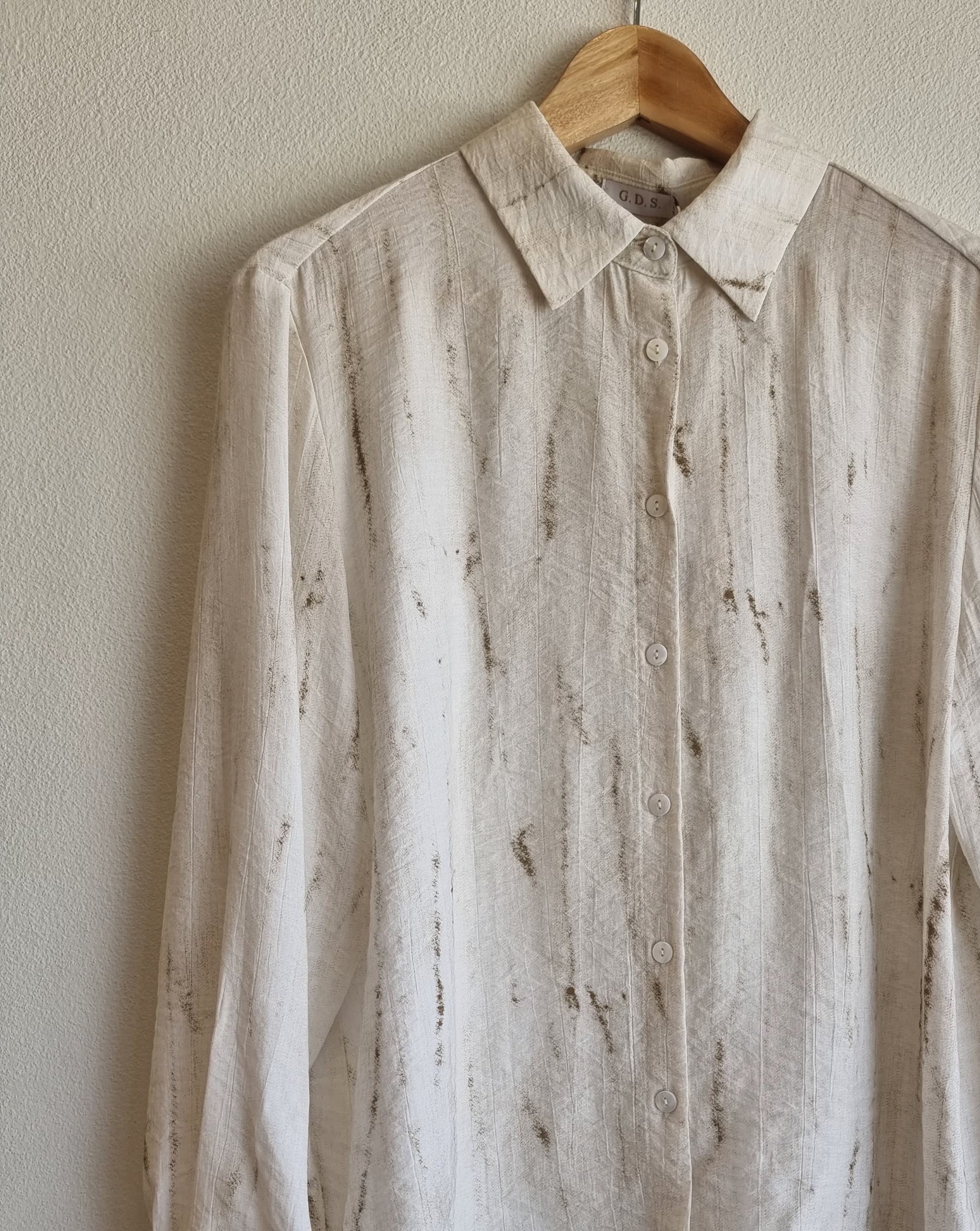 “Oceanus wrinkle-free lightweight marble-pattern shirt hanging on a wooden hanger against a neutral wall – front view product detail – Nova Lux”