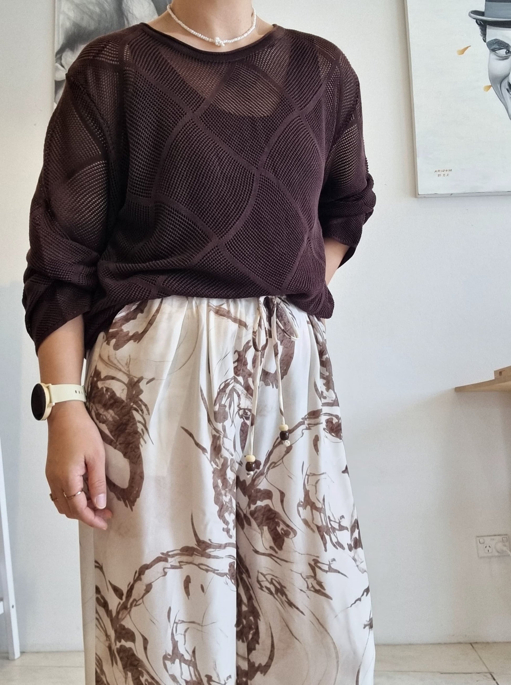 Brown Tencel mesh knit long-sleeve top styled with beige abstract print wide-leg pants.