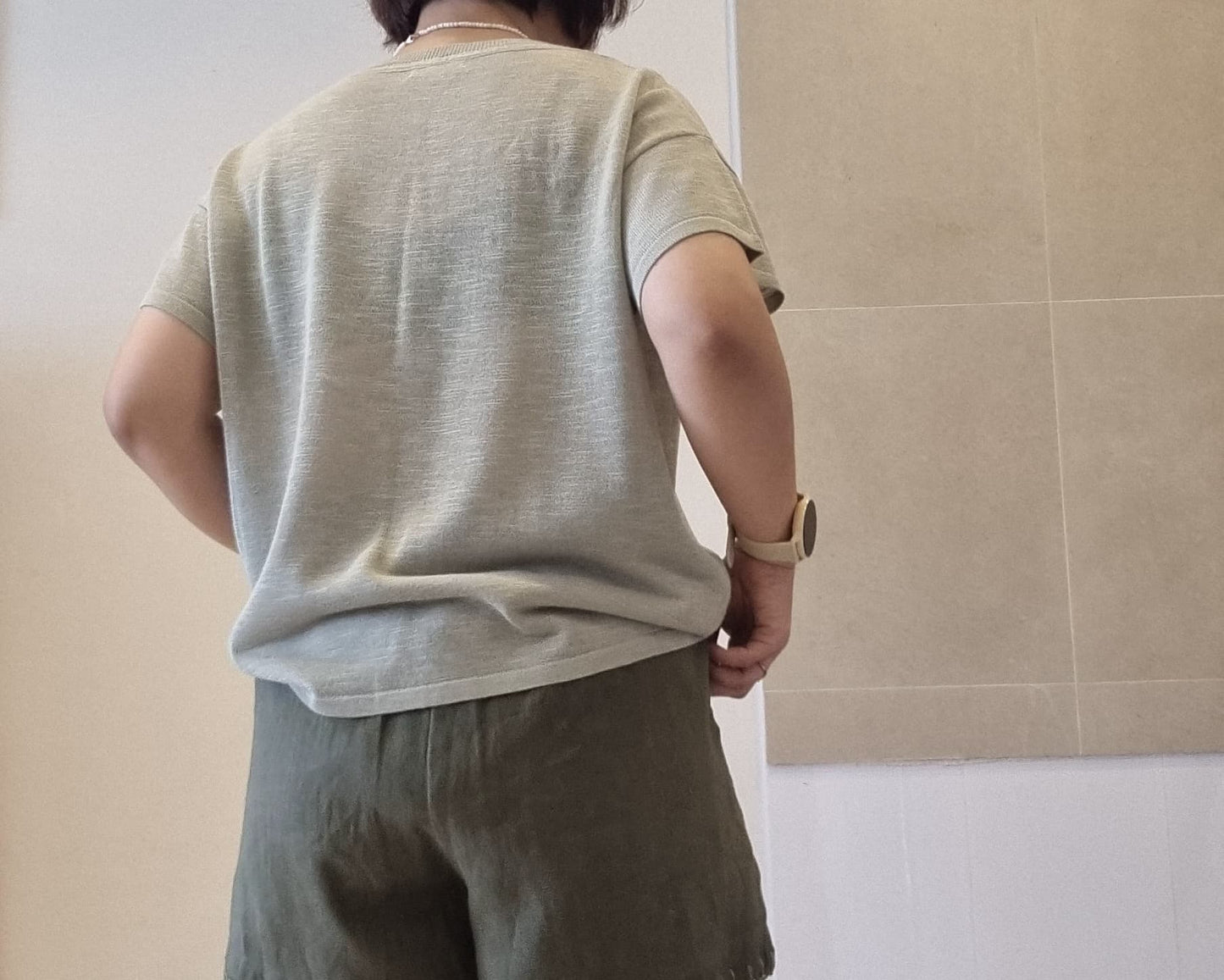 Back view of soft green viscose knit top, relaxed fit, lightweight fabric