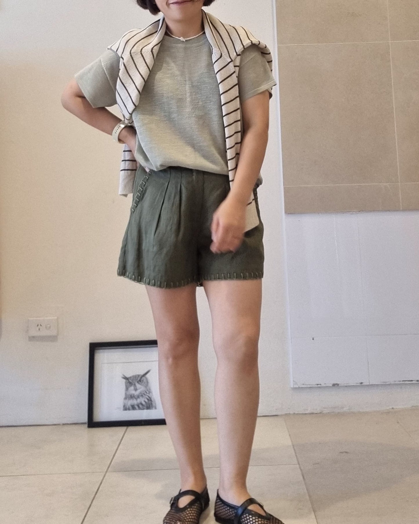 Soft green viscose knit top styled with striped cardigan and green shorts, relaxed fit