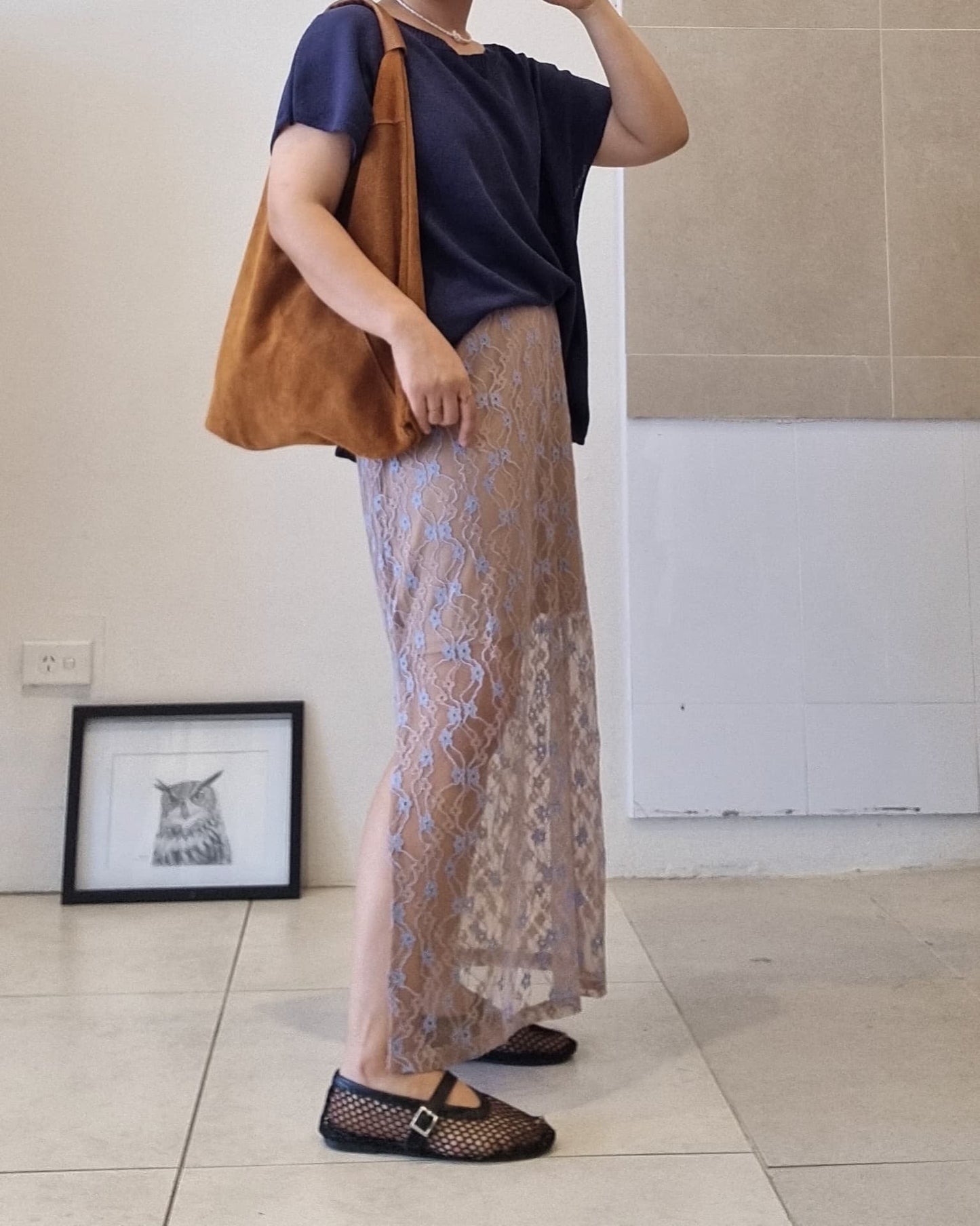 Side view of a navy cotton relaxed-fit top with soft drape and off-shoulder neckline.