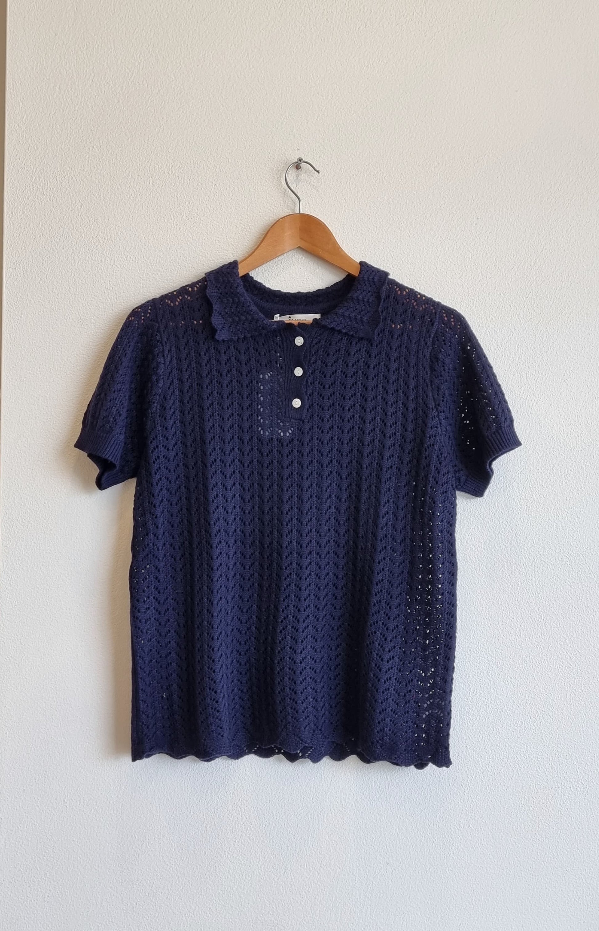 Navy lace collar knit top with delicate textured pattern on hanger