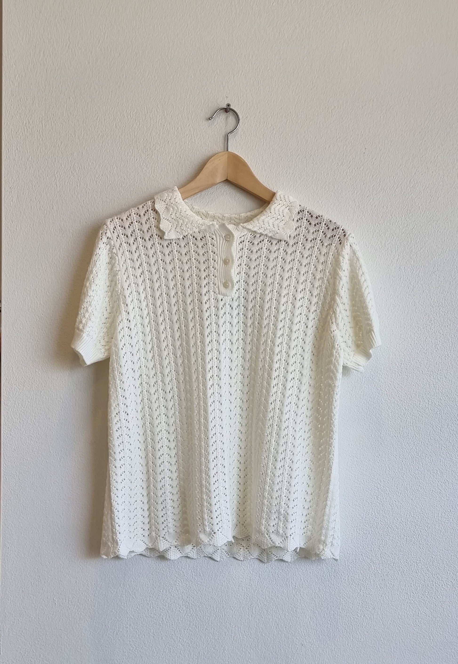Cream lace collar knit top displayed on hanger