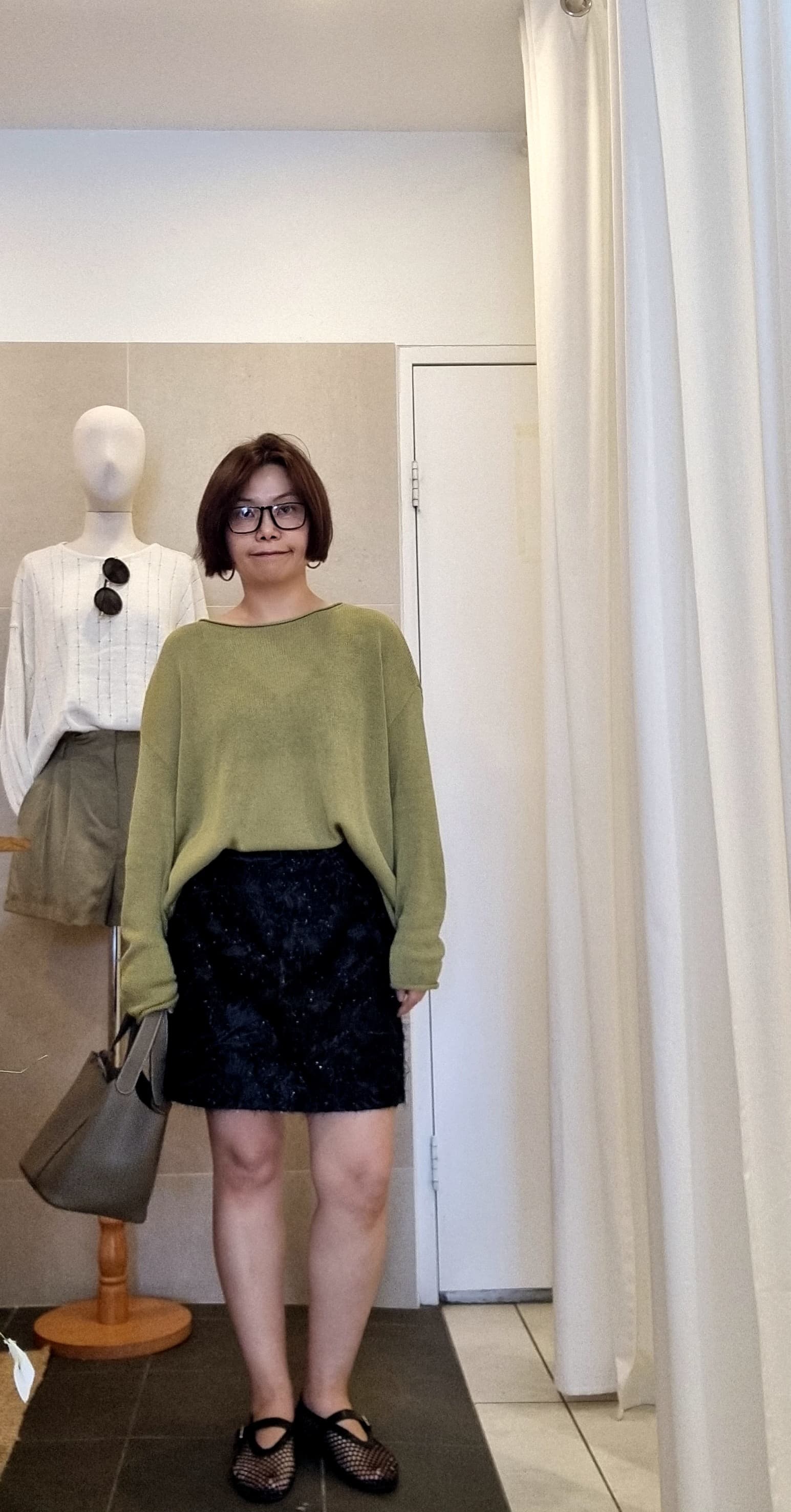 Front view of model wearing green lightweight knit top, relaxed fit silhouette