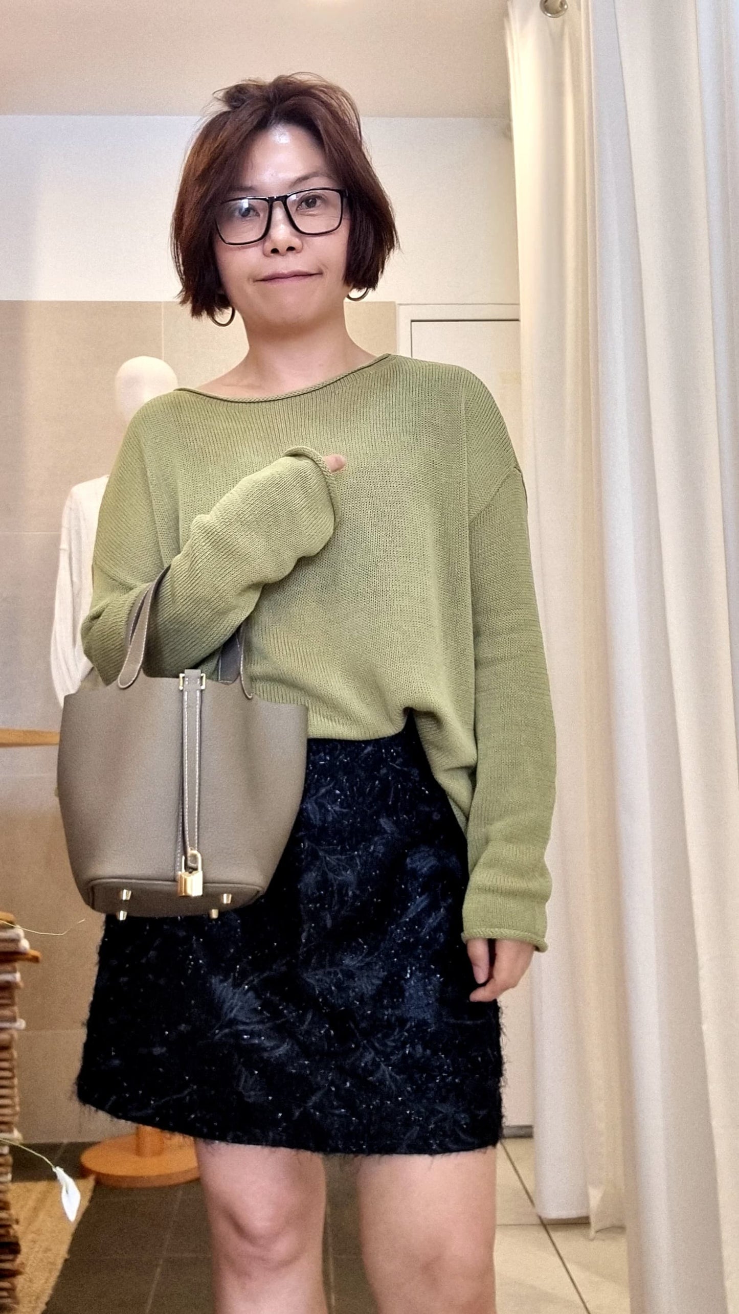 Model wearing green lightweight knit top, relaxed fit casual look