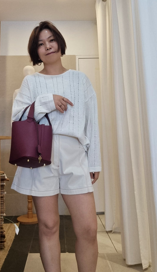 Model wearing cream ribbed knit top with cream shorts, relaxed fit