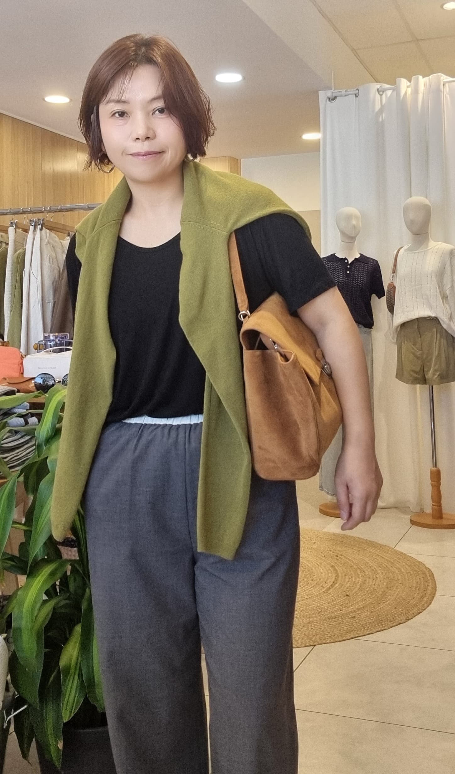 Model styling camel suede bag with casual outfit, front view