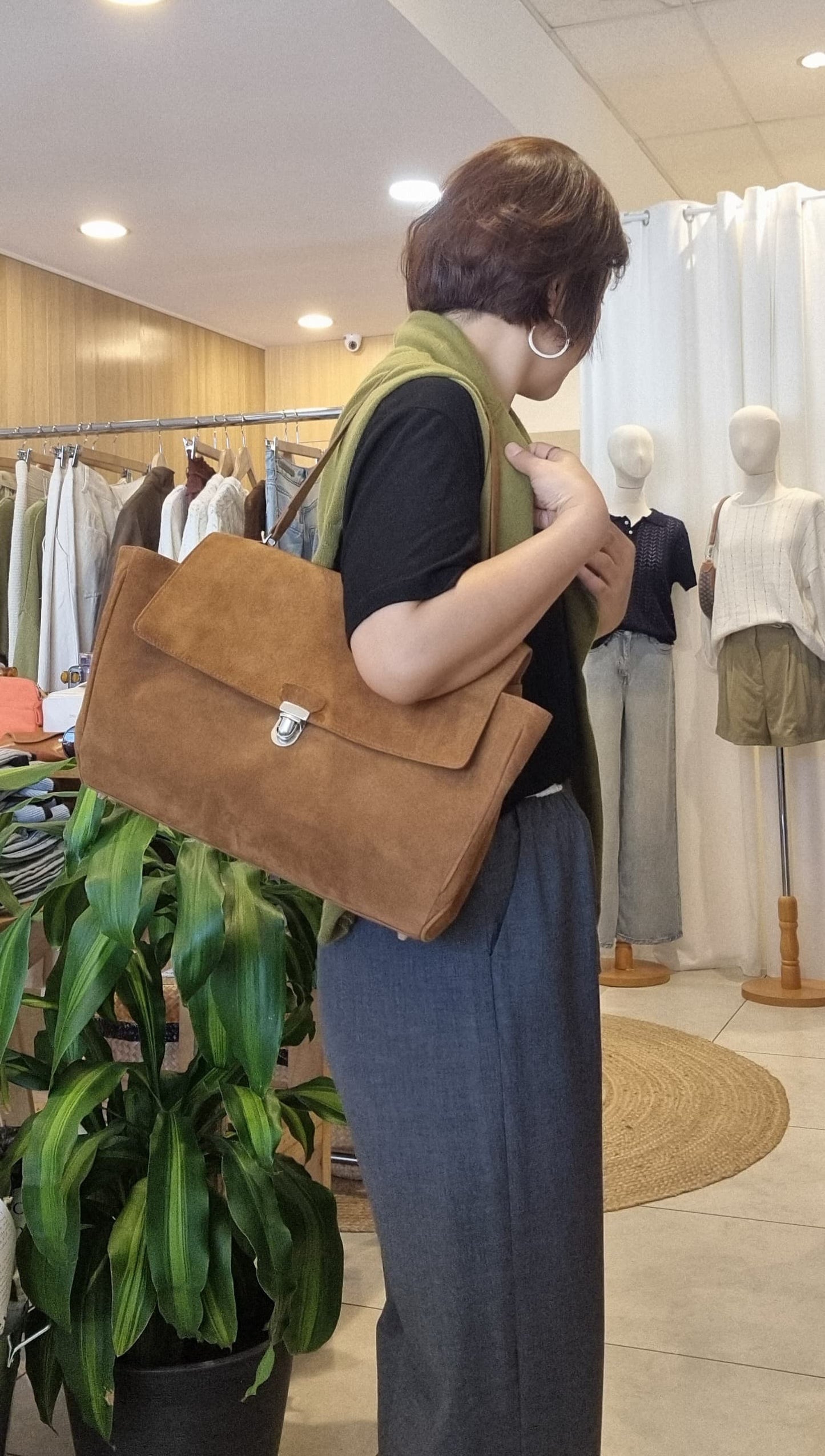 Model wearing camel suede bag over the shoulder, side view