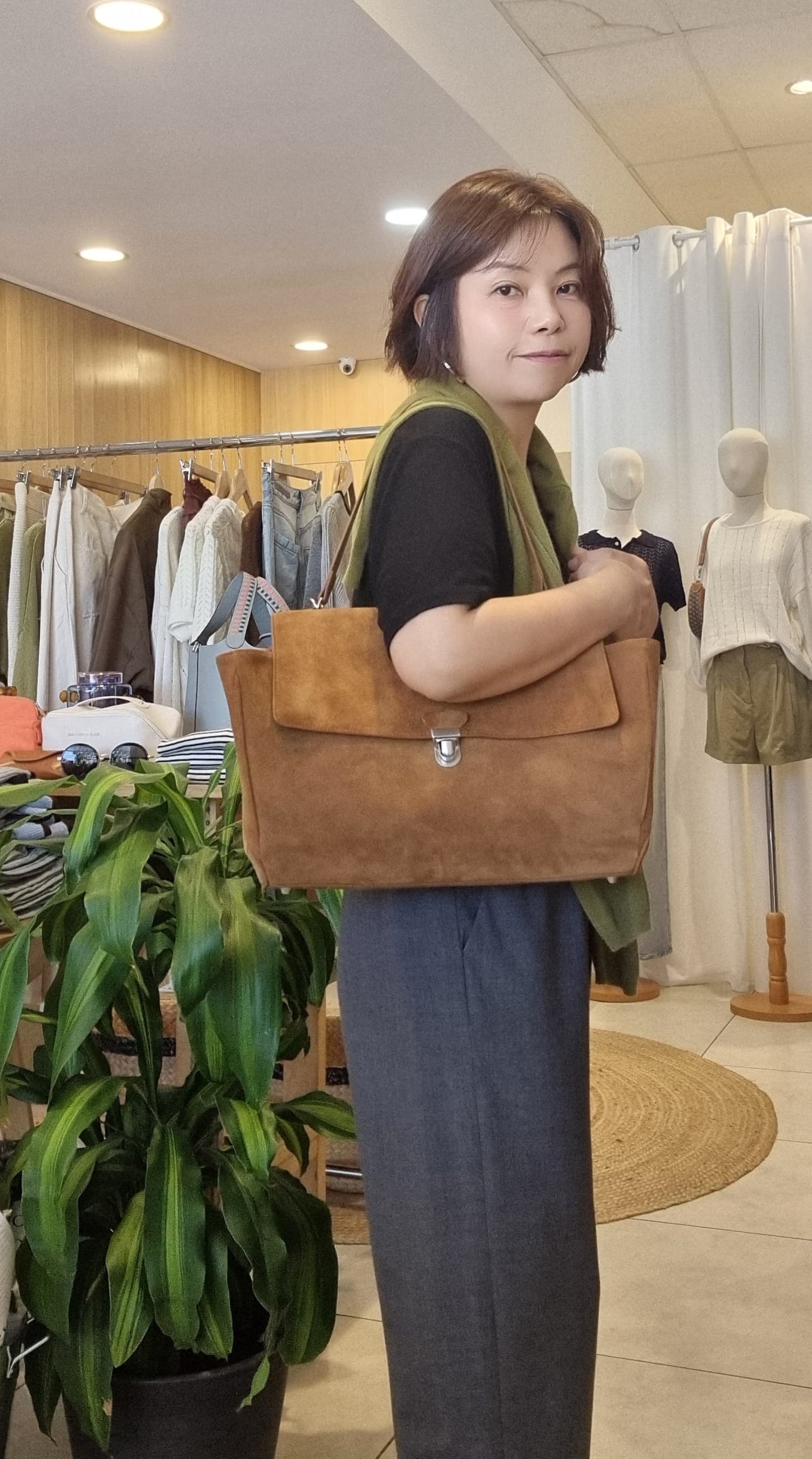 Model styling camel suede bag with casual outfit, side angle