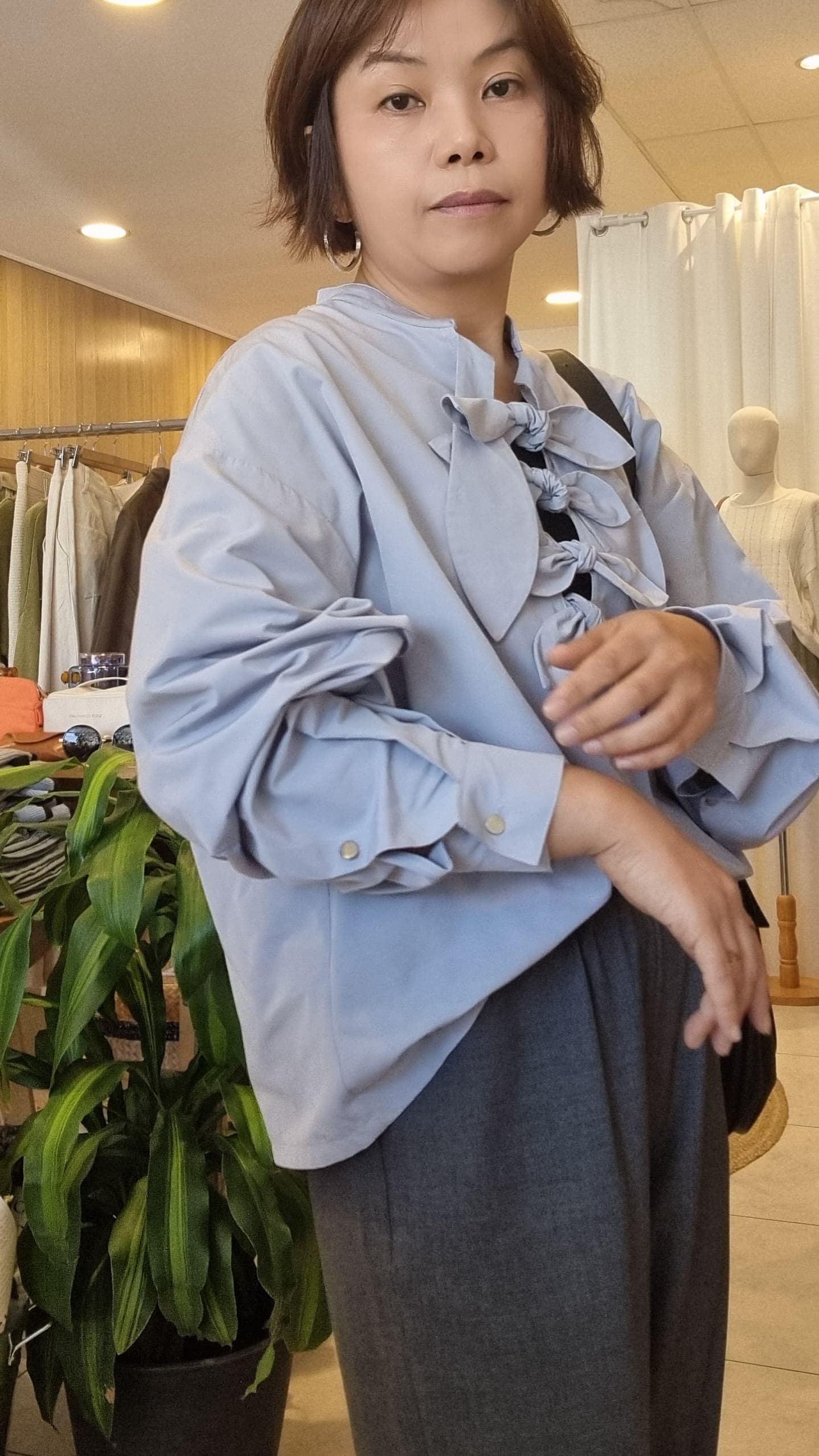 Model wearing Cloud Blue Ribbon Top, side angle highlighting relaxed fit