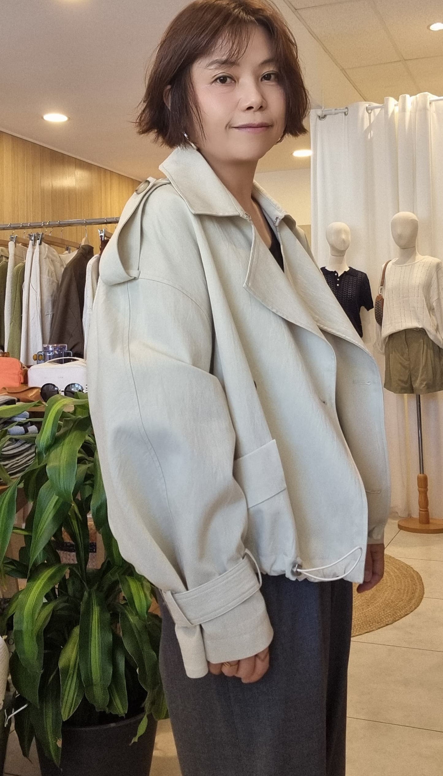 Side view of Cream Breeze Short Trench showing cropped length