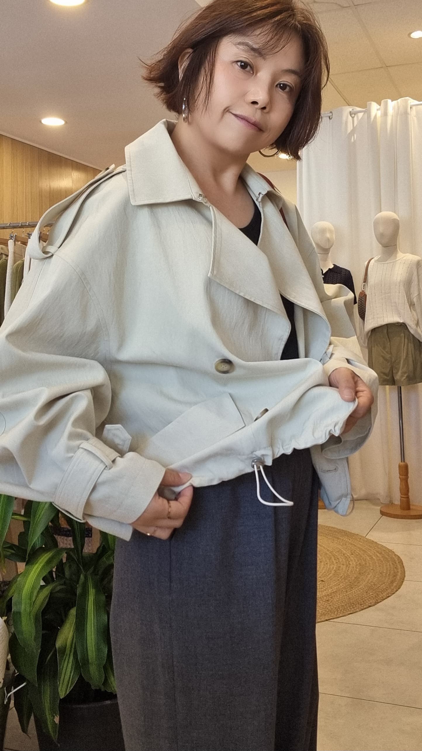 Model wearing Cream Breeze Short Trench, side angle with relaxed silhouette