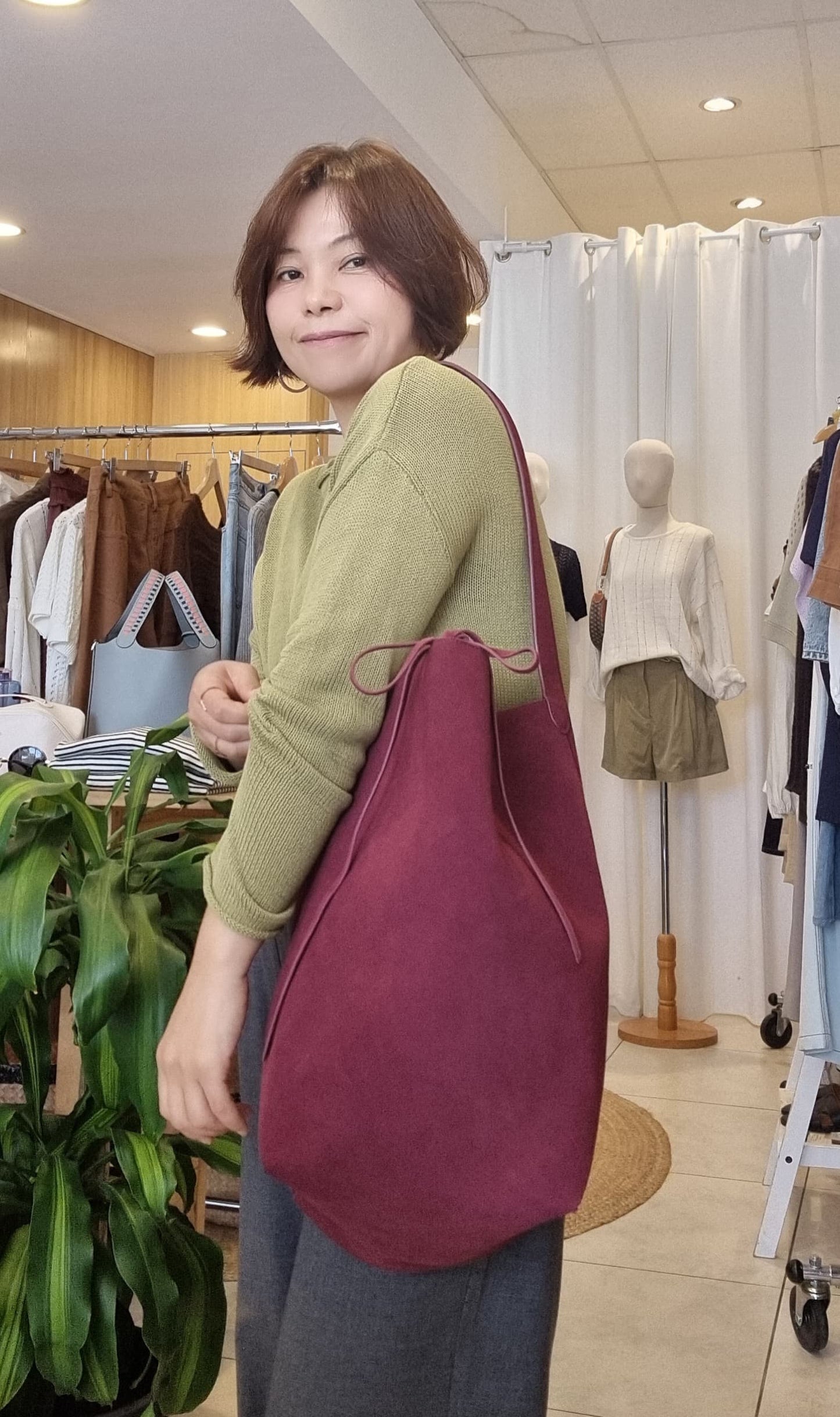 Burgundy suede tote bag carried by model, everyday styling