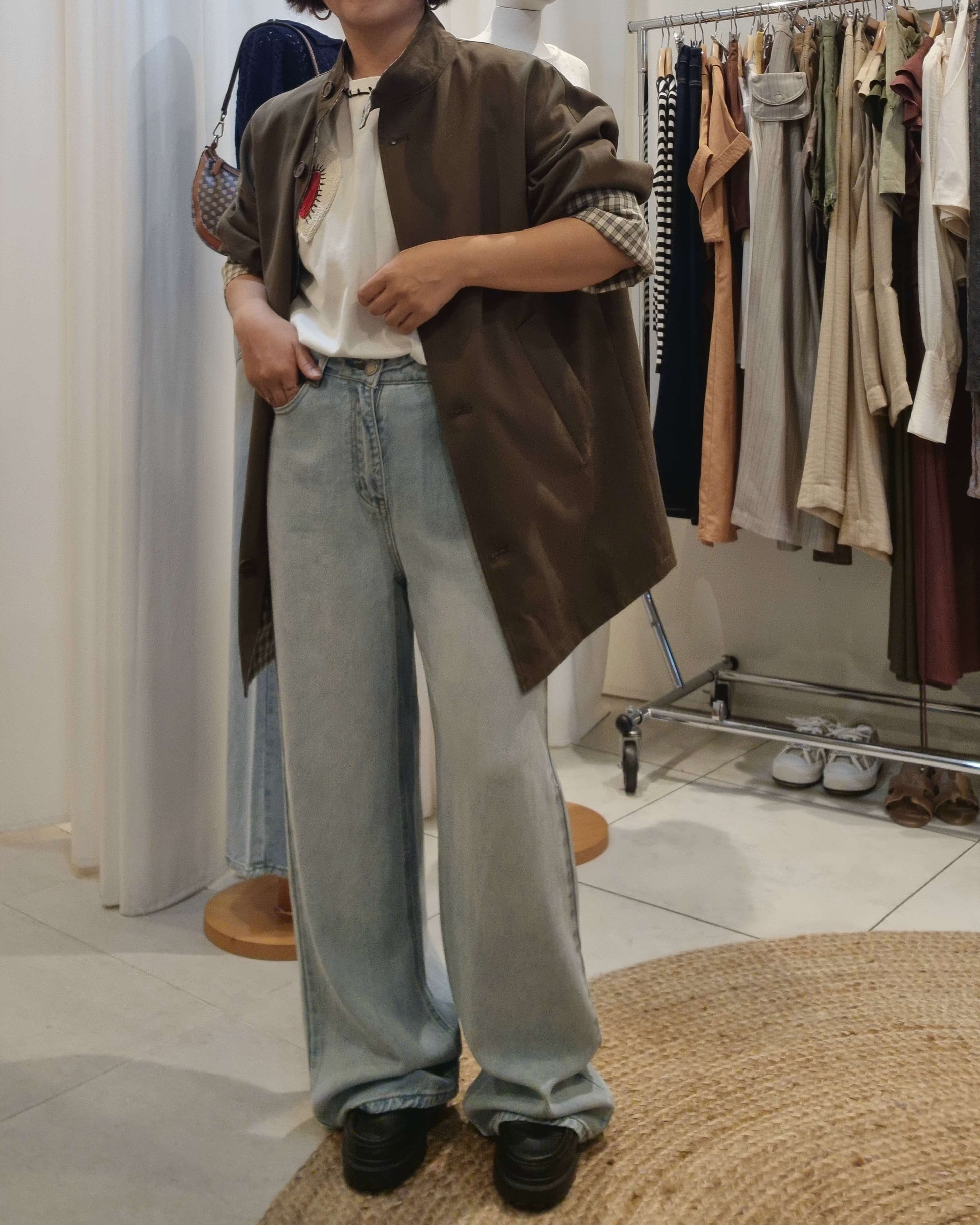 Model in khaki oversized trench coat and denim jeans, side profile