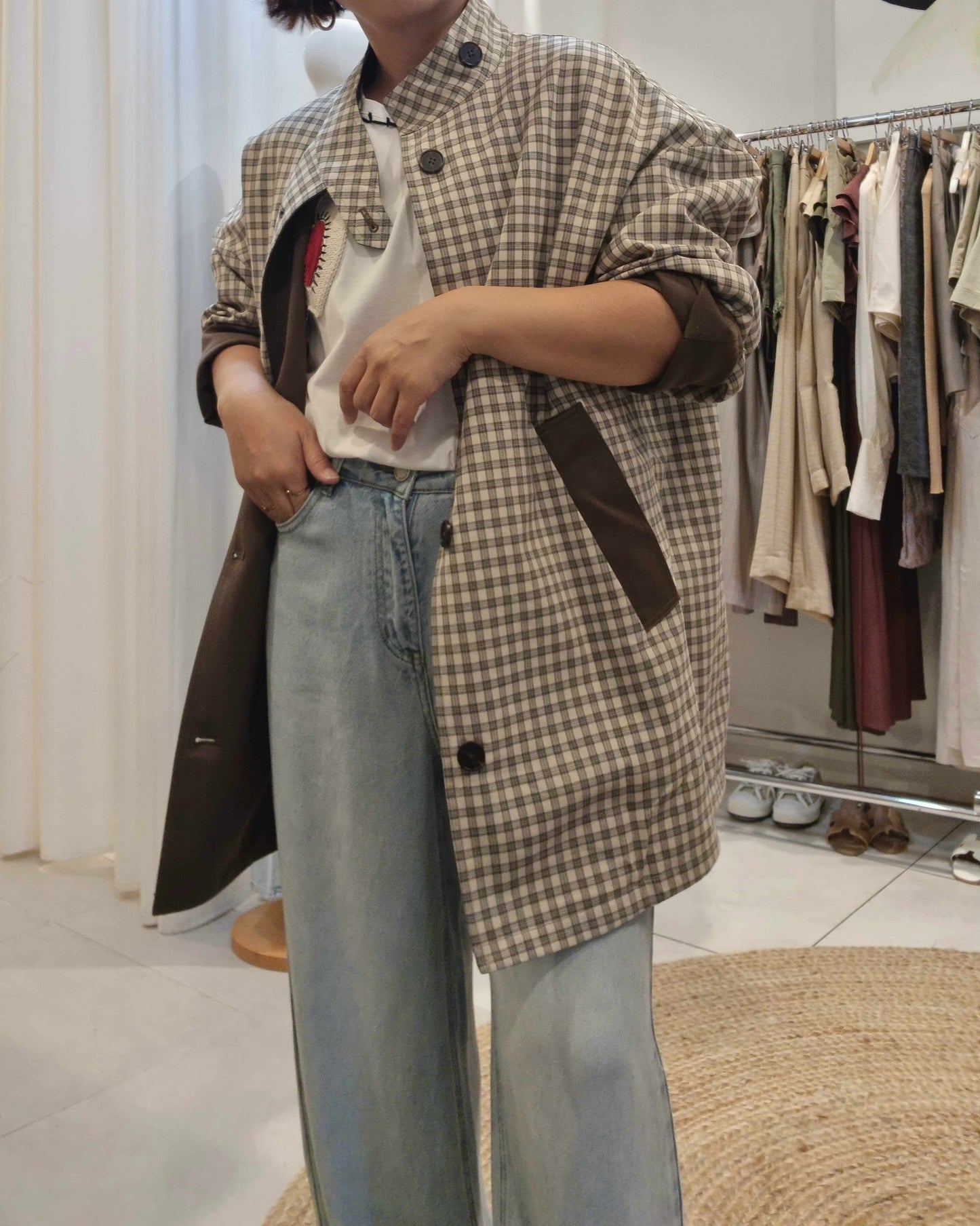 Front view of khaki reversible trench coat worn with check pattern side showing