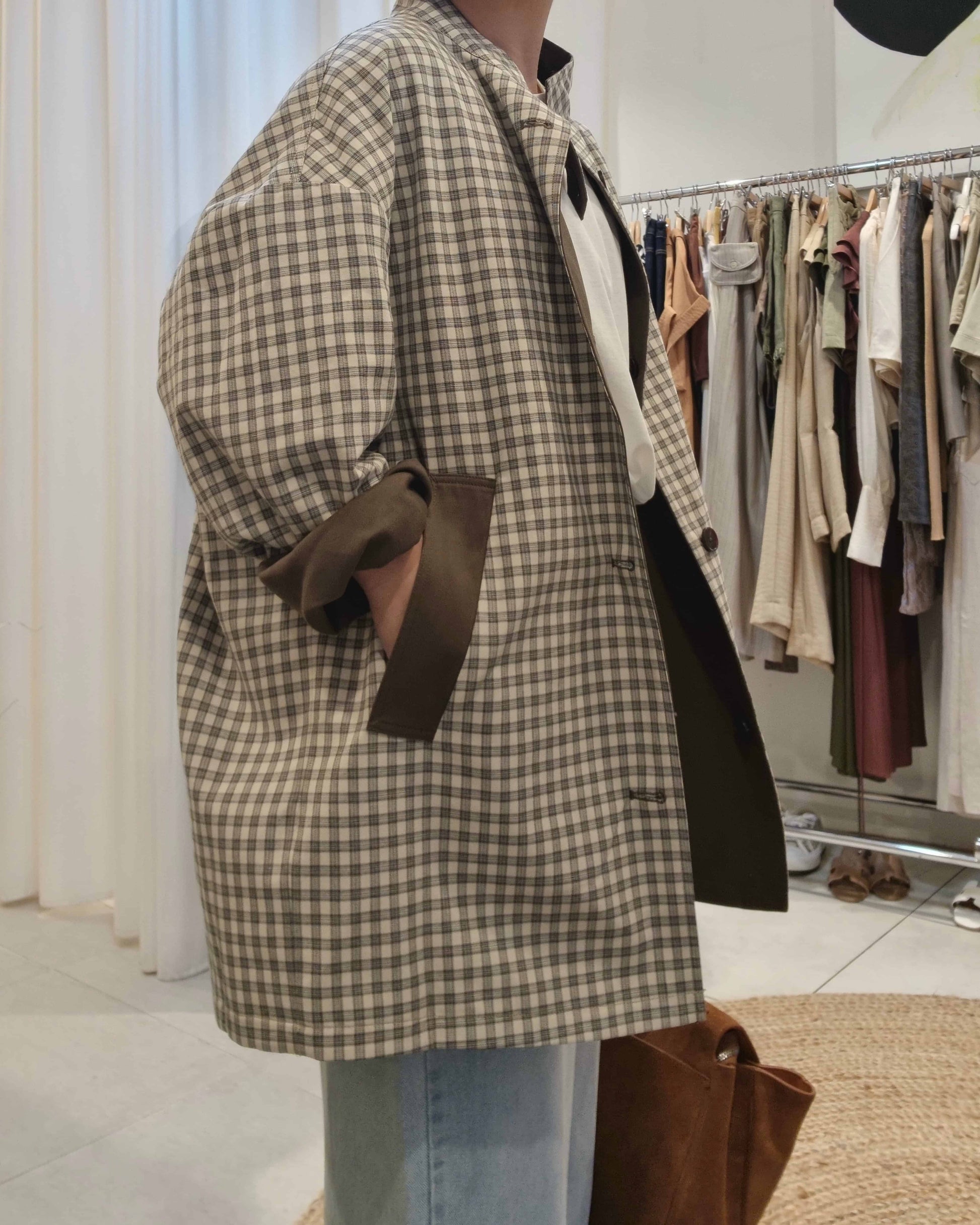 Side angle of reversible trench coat showing check pattern lining