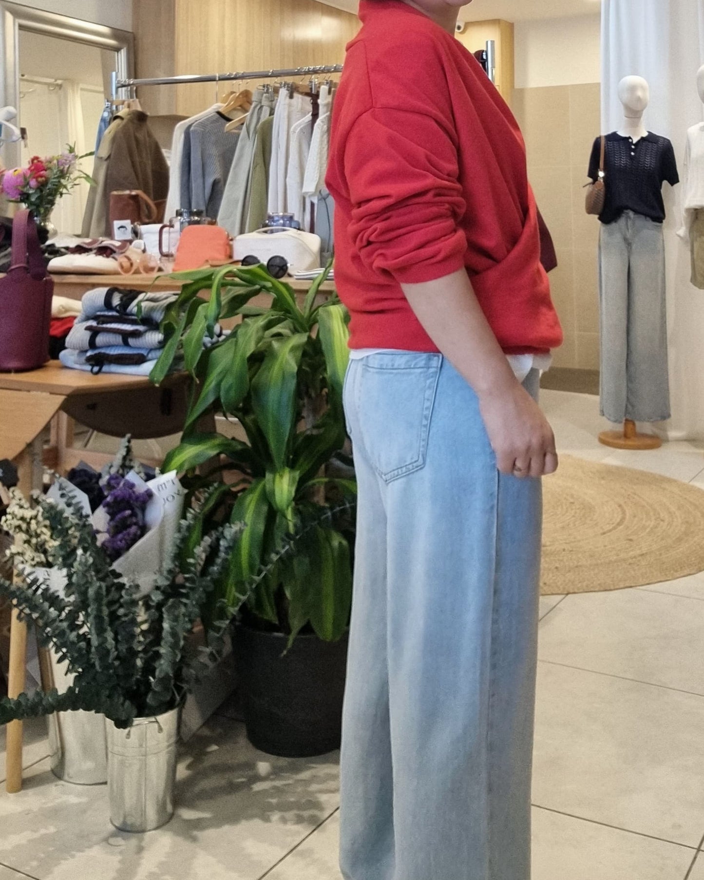Side angle of red wrap knit styled with jeans, relaxed fit look