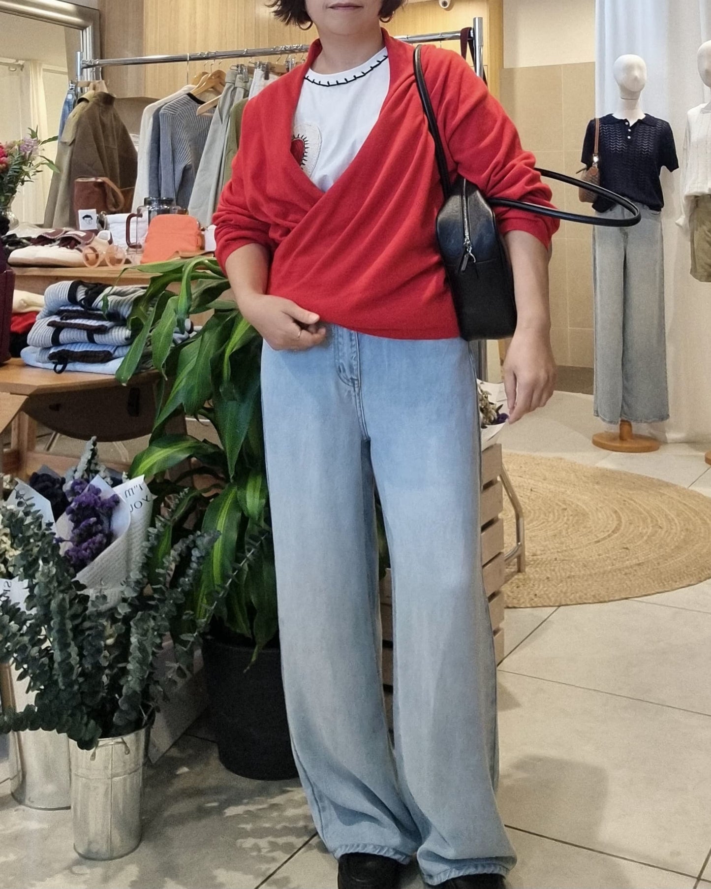 Model wearing red wrap knit with blue jeans, front view casual styling