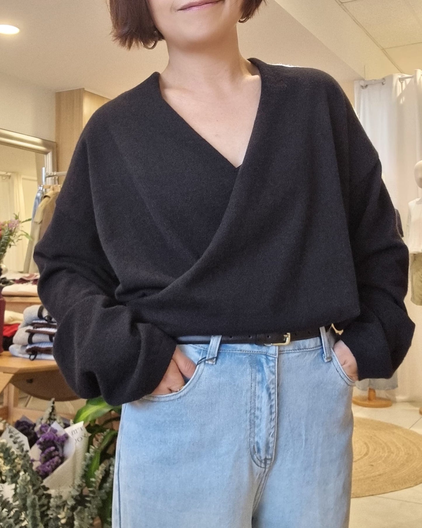 Front view of model in Black wrap knit and denim jeans, relaxed everyday look
