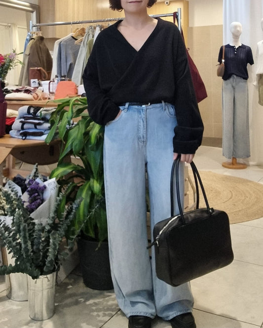 Model wearing Black wrap knit with blue jeans, front view casual styling