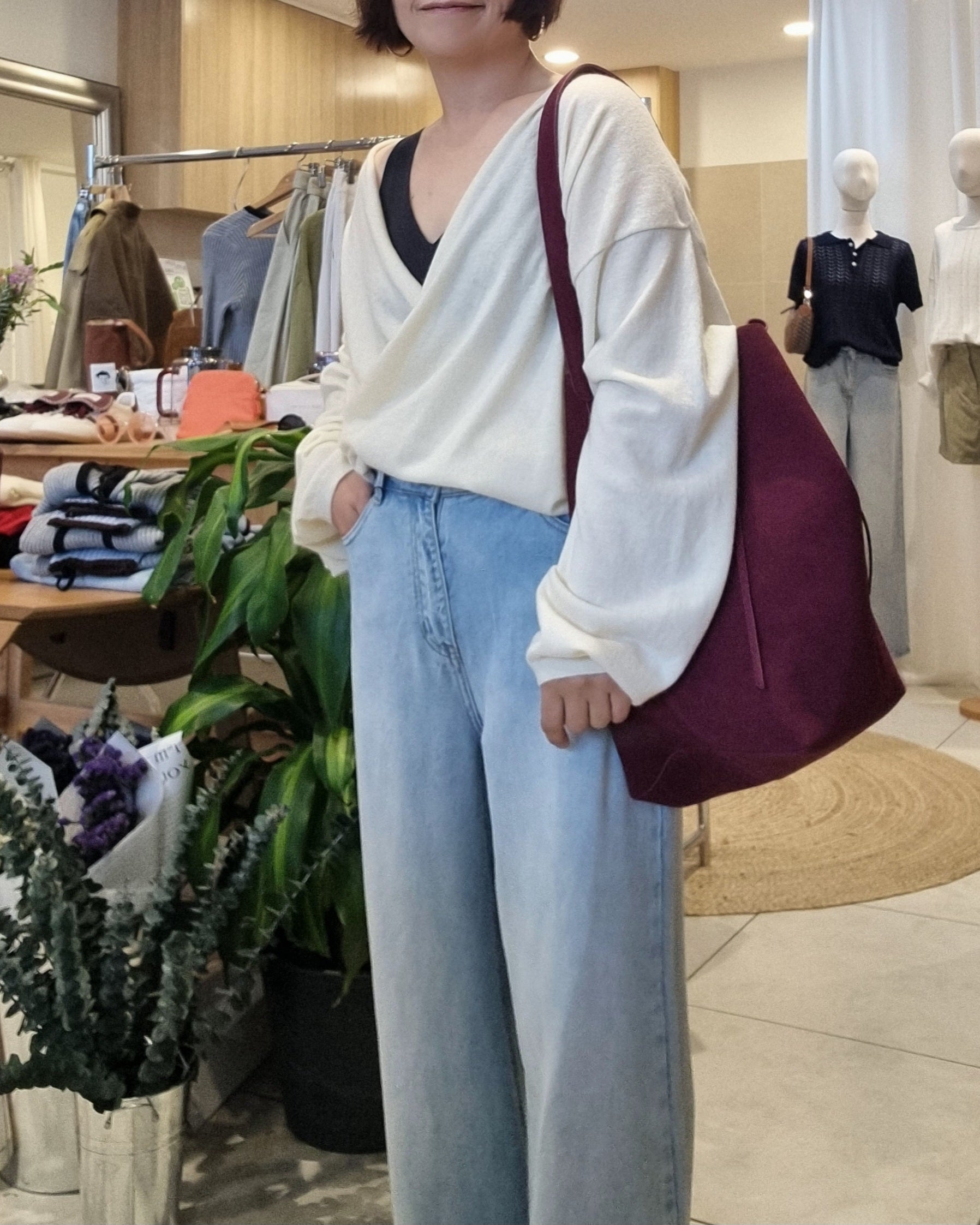 Side view of model wearing cream wrap knit with draped silhouette