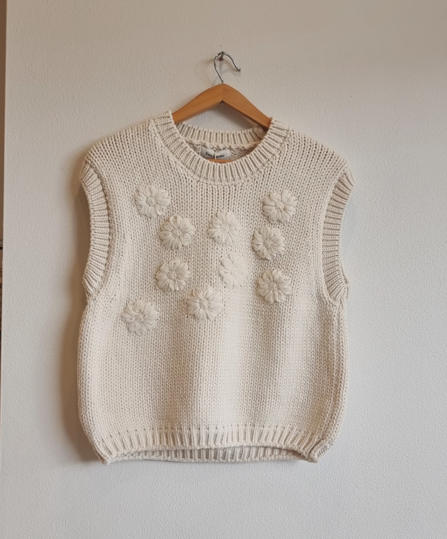 Model wearing cream daisy flower knit vest casual outfit