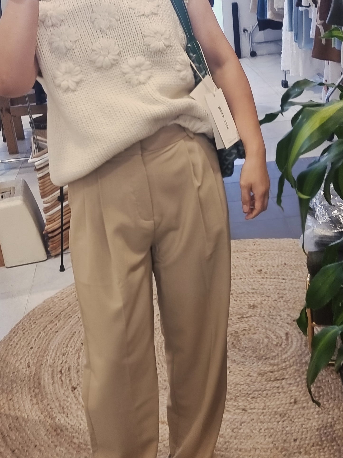 Model wearing cream daisy flower knit vest front view with Goyad bag Green color