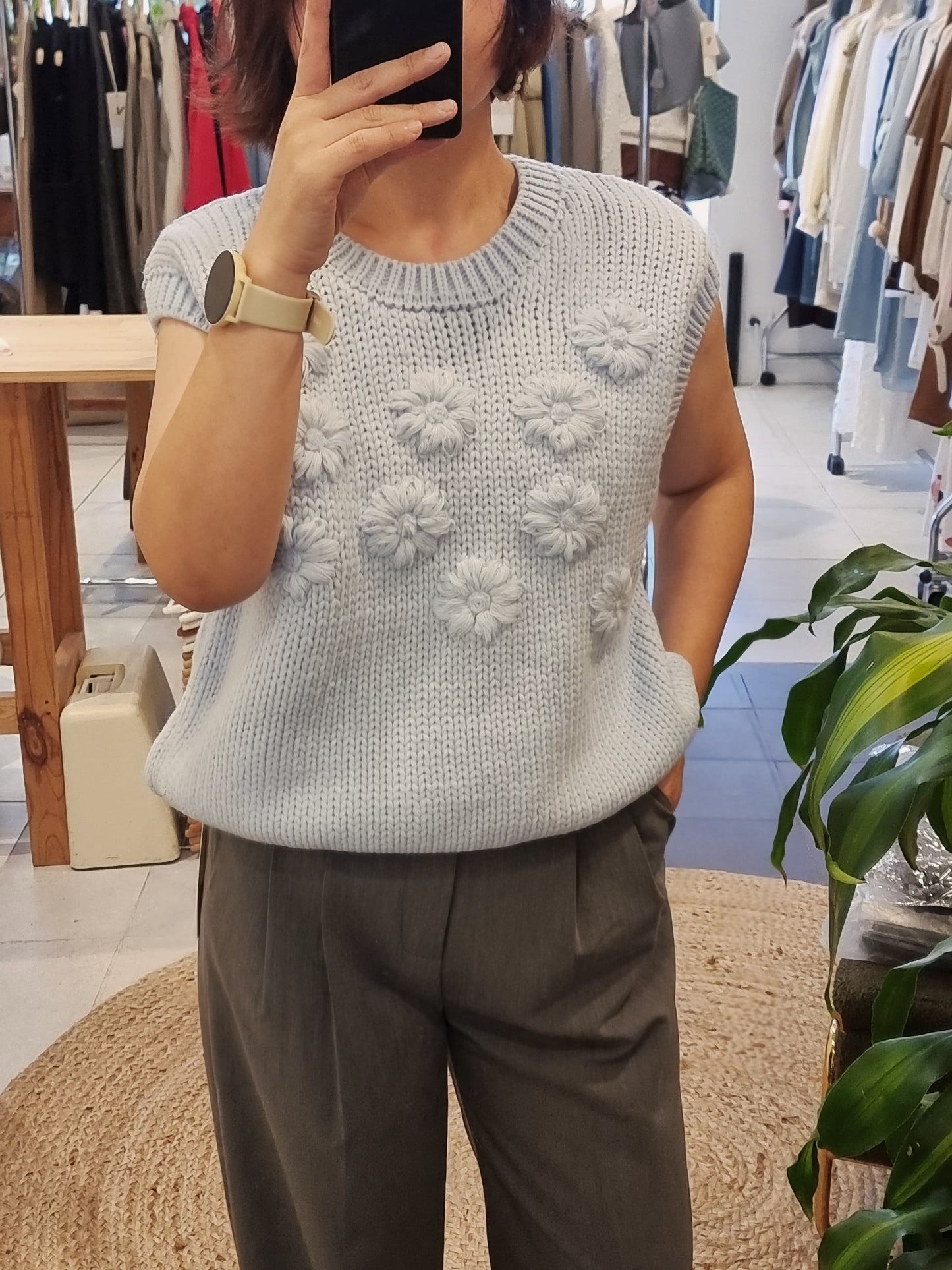 Model wearing blue daisy flower knit vest casual style