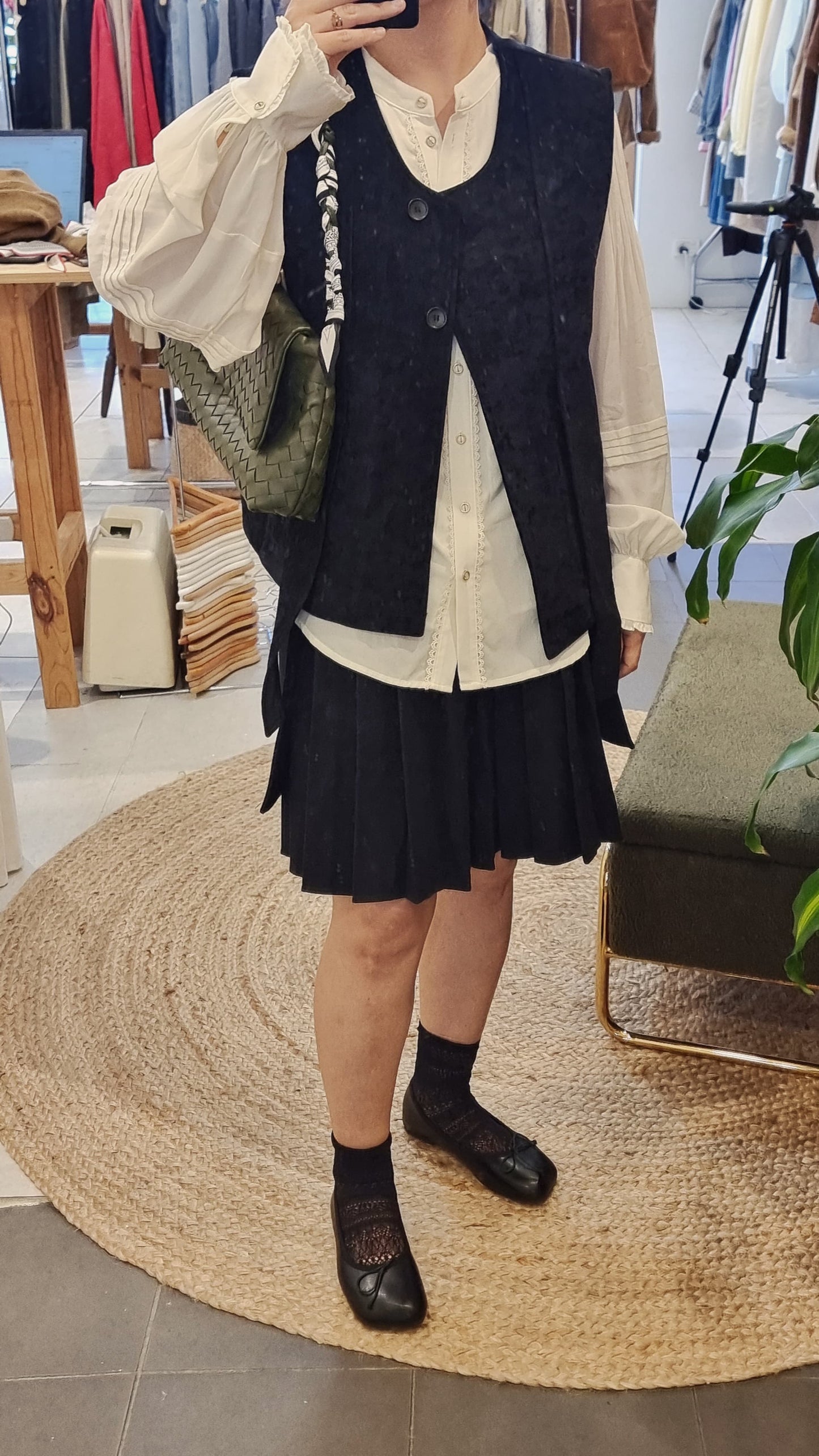 Black corduroy vest styled with blouse and skirt, elegant layered look