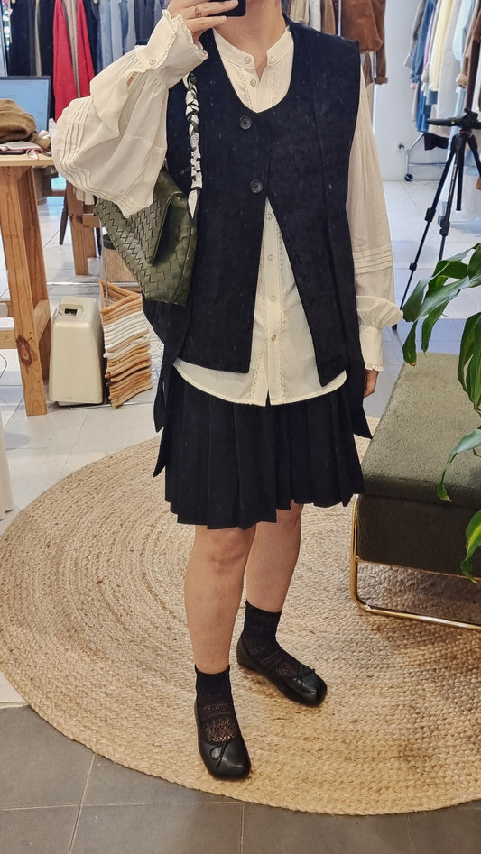 Black corduroy vest styled with blouse and skirt, elegant layered look