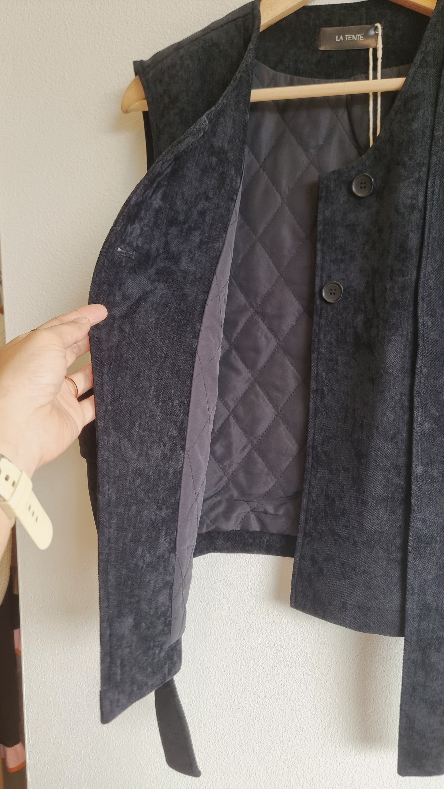Black corduroy vest inside lining and stitching detail on hanger