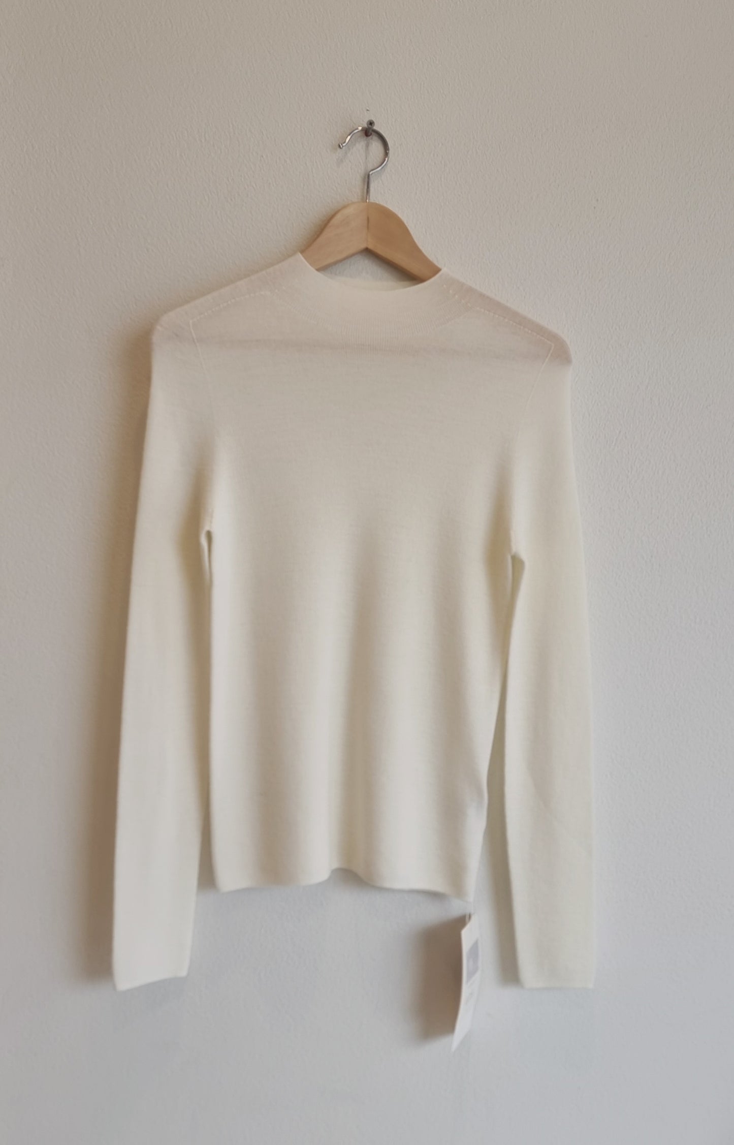 Cream wool sweater on hanger