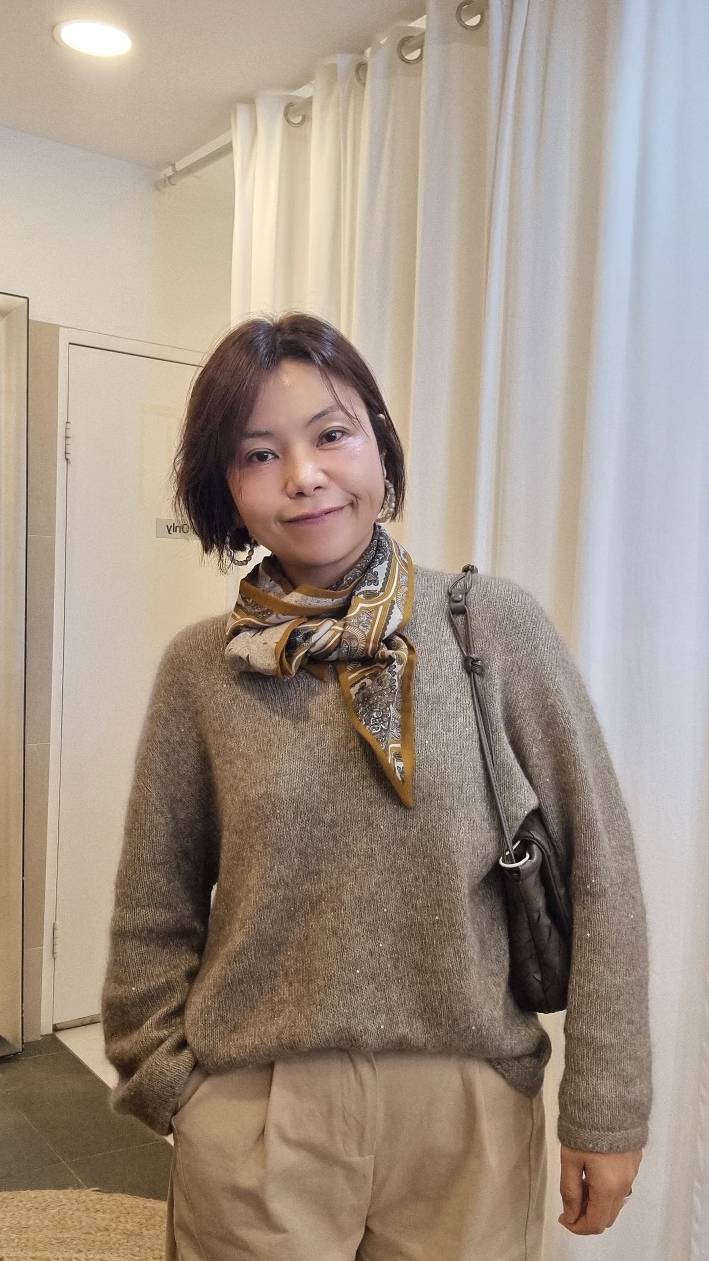 model wearing beige knit with cashmere silk scarf styled around neck