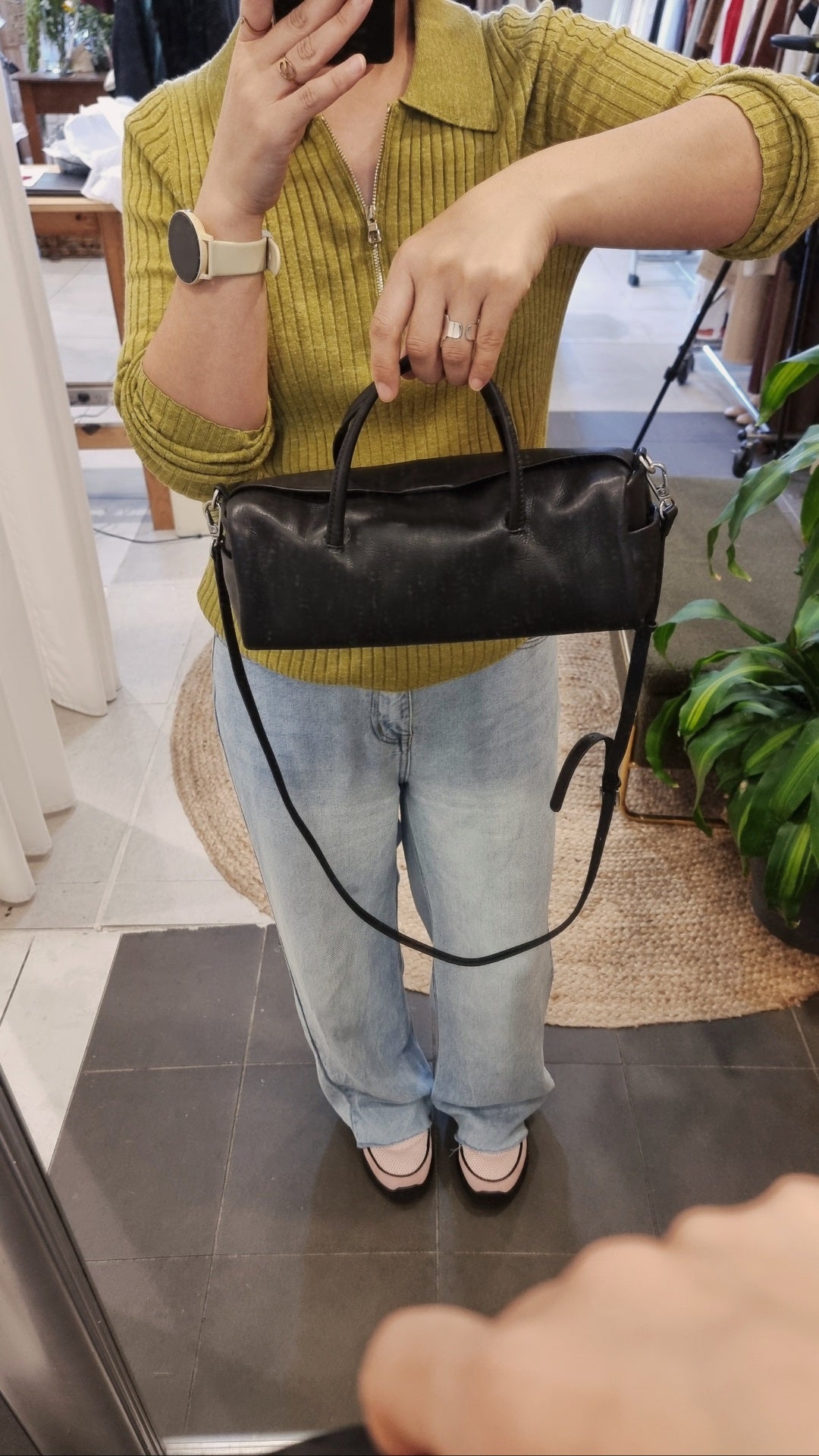 black leather cylinder bag styled crossbody on model