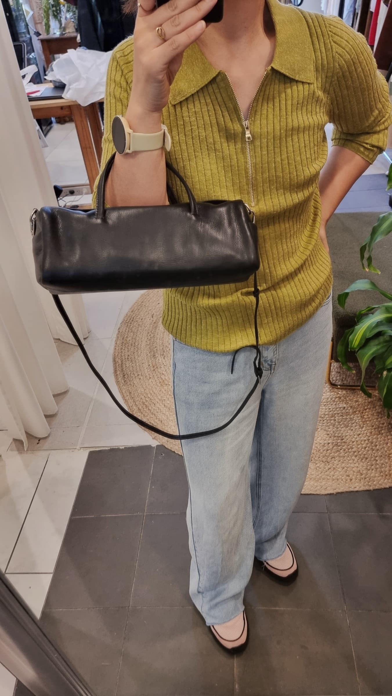 black leather cylinder bag worn with casual outfit