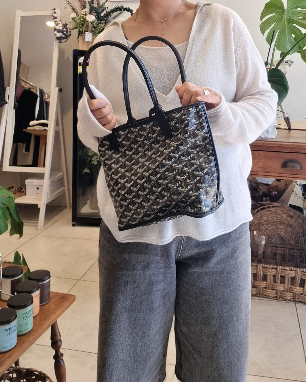 Model wearing a soft white knit tank set with relaxed fit and Goyad bag