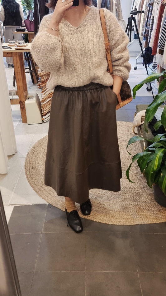 Brown faux leather A-line skirt styled with a soft knit sweater