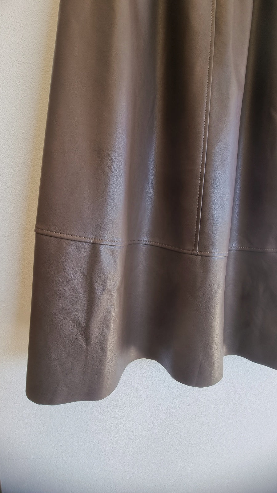 Soft faux leather texture detail on brown midi skirt